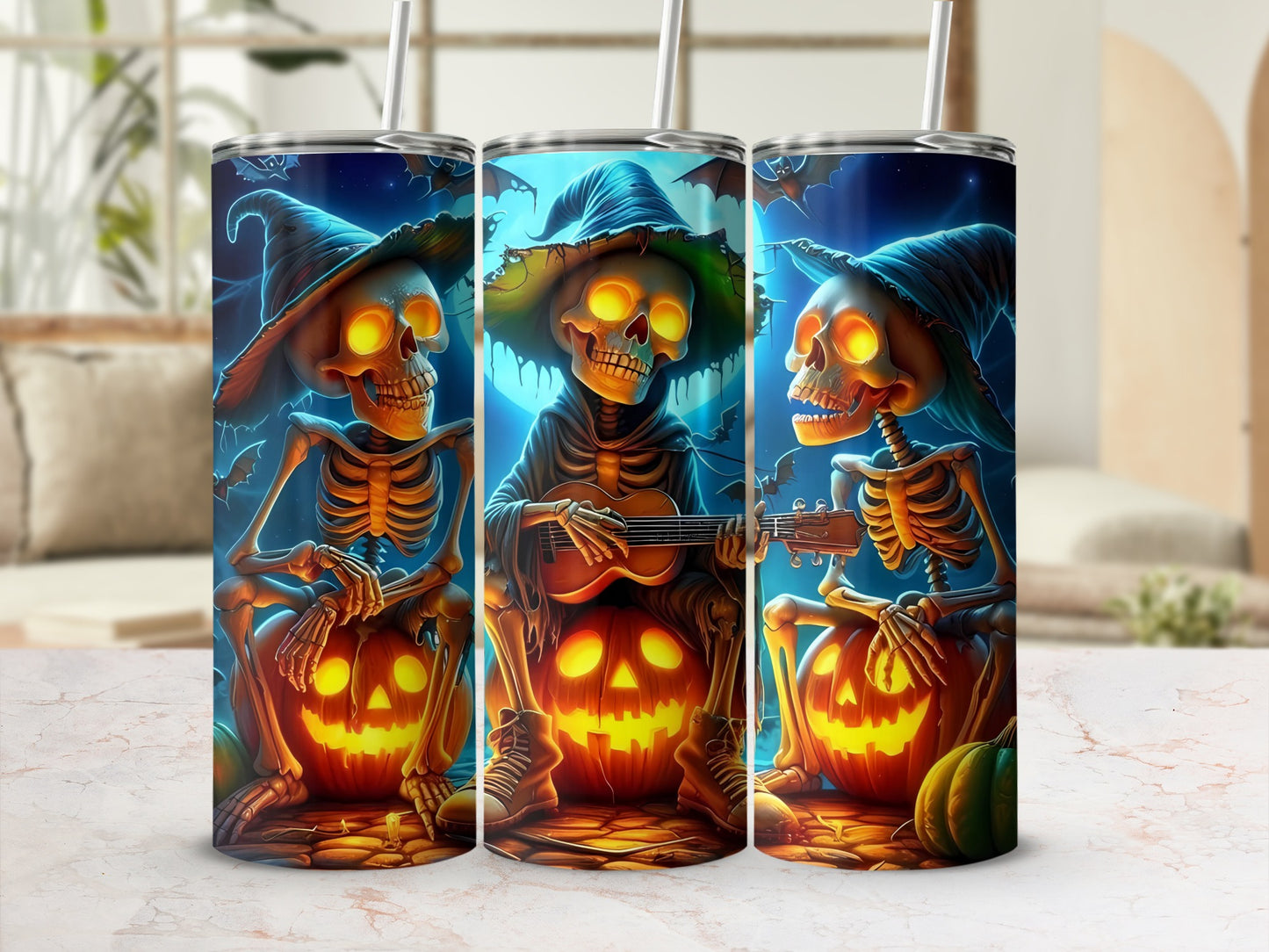 Three tumblers with Halloween skeletons playing guitars and sitting on pumpkins.
