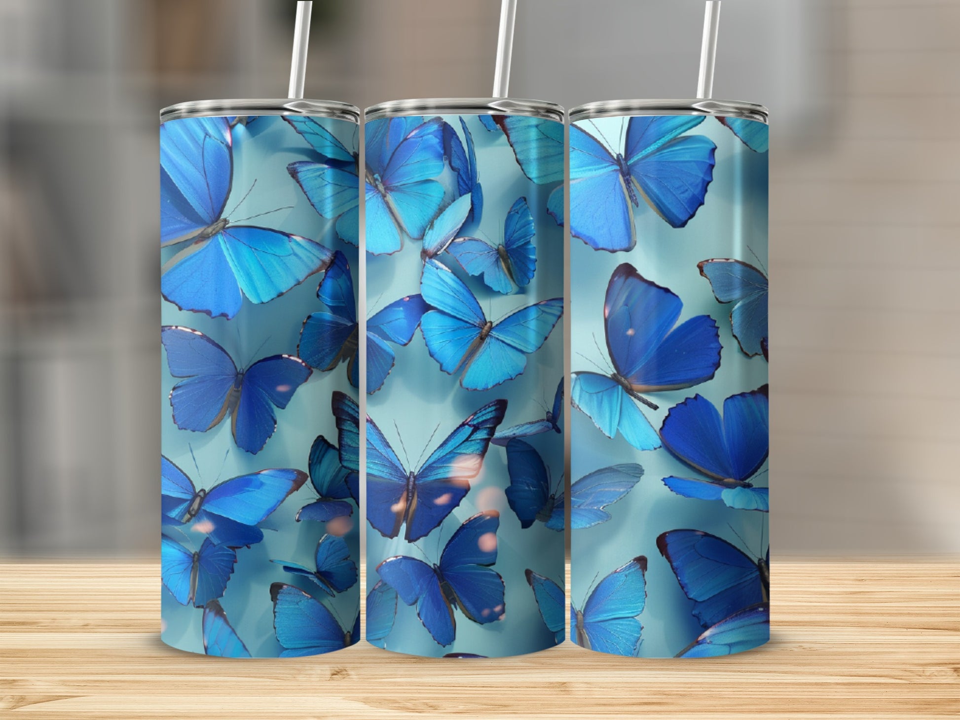 Three blue butterfly tumblers on a wooden surface.