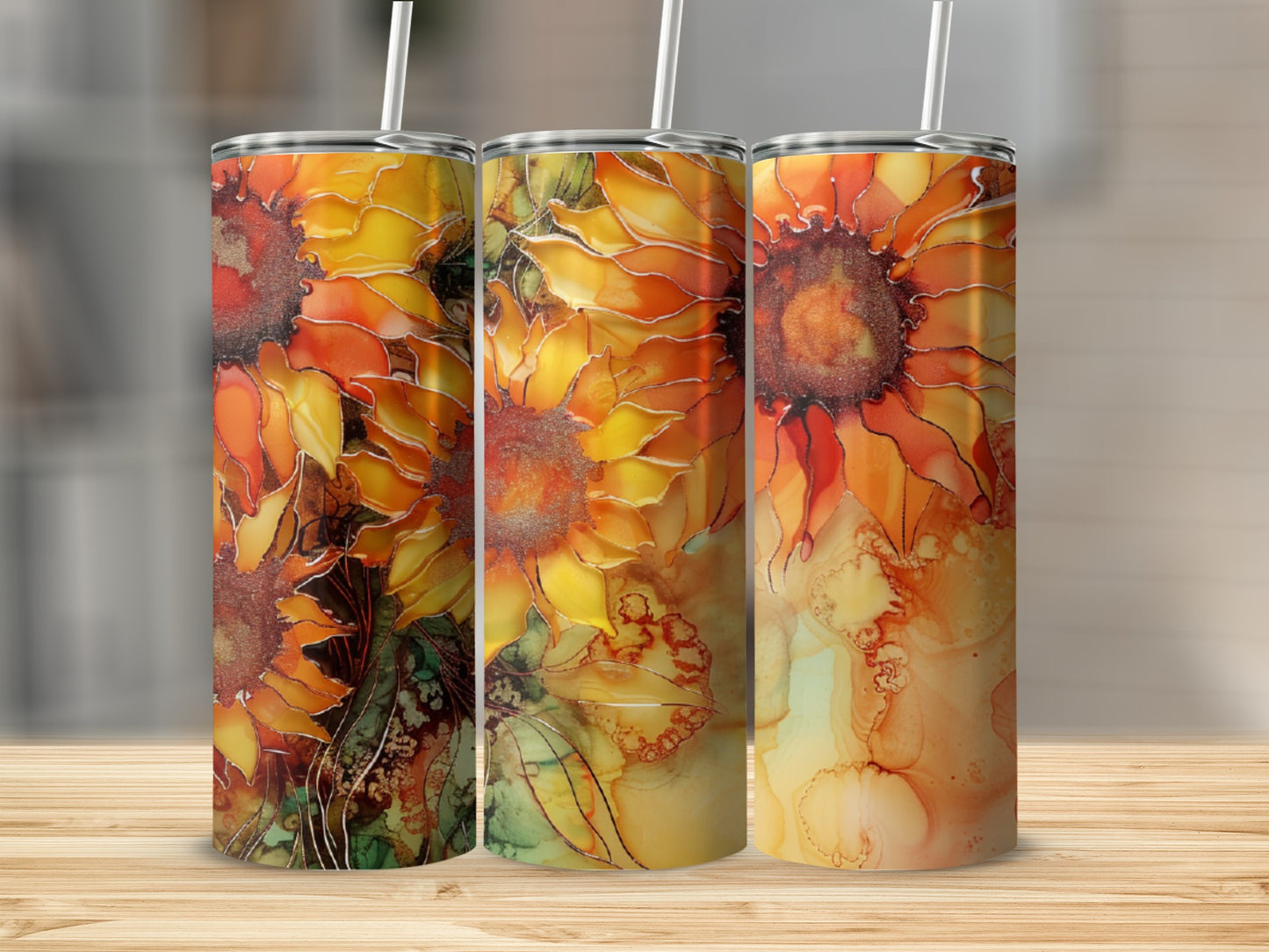 Three tumblers with a vibrant sunflower pattern on a wooden surface.