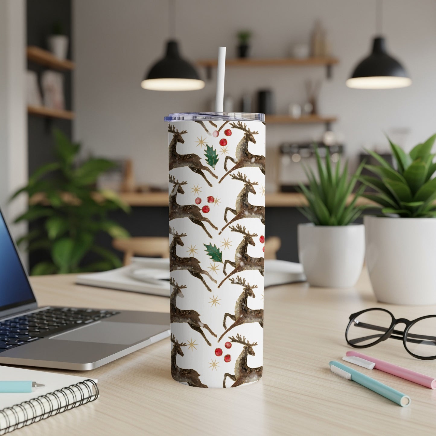 White tumbler with repeating pattern of brown reindeer and red berries.