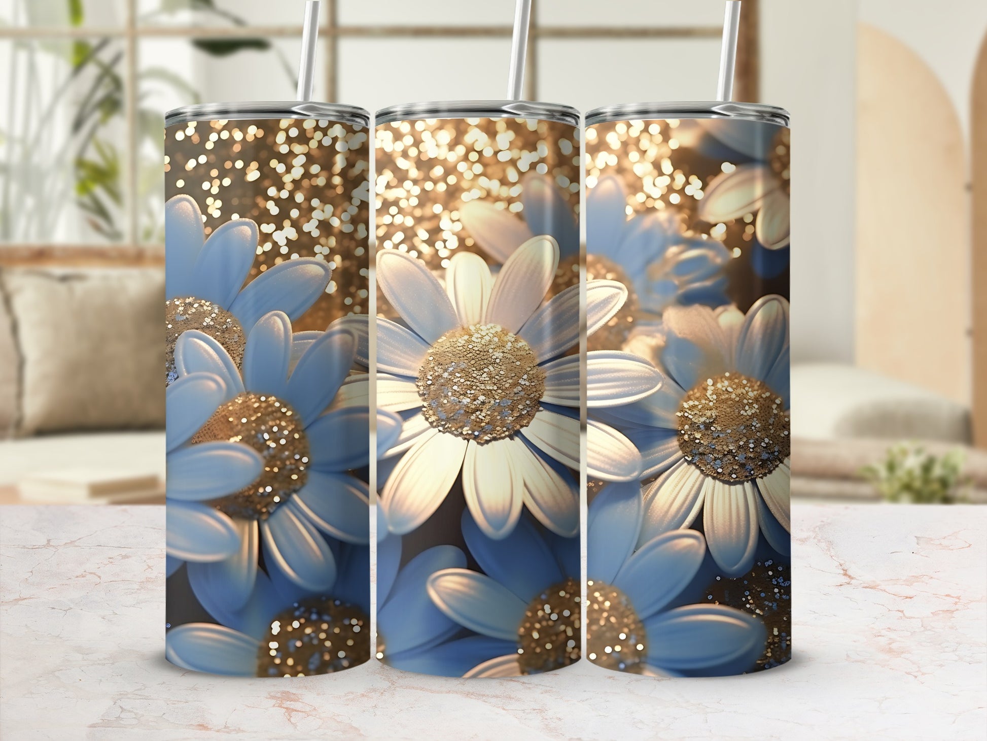 Three tumblers with blue daisies and gold glitter against a blurred background.