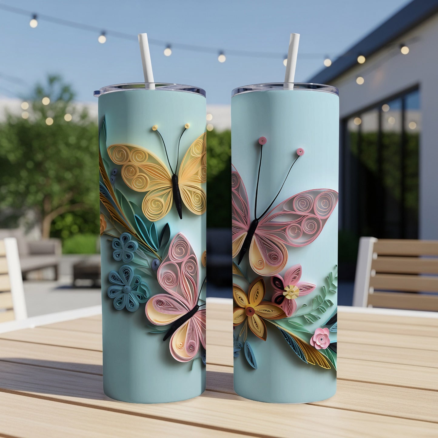 Aqua tumblers with quilled butterflies and flowers on a wooden table.