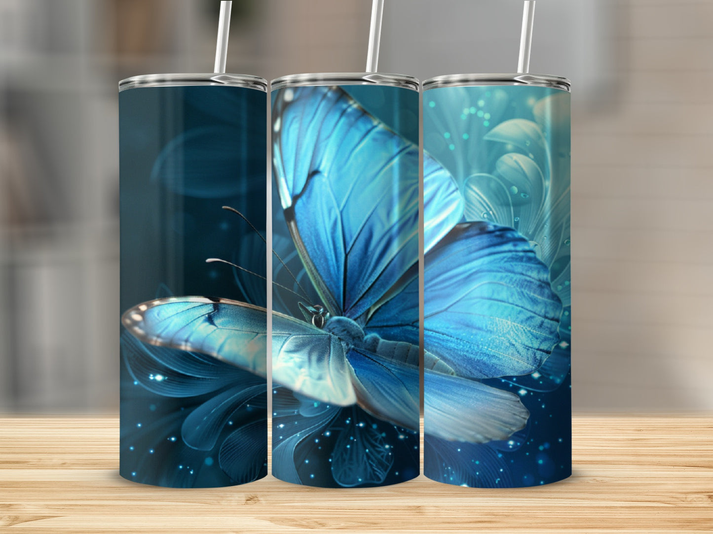 Blue butterfly artwork on three insulated tumblers with straws.