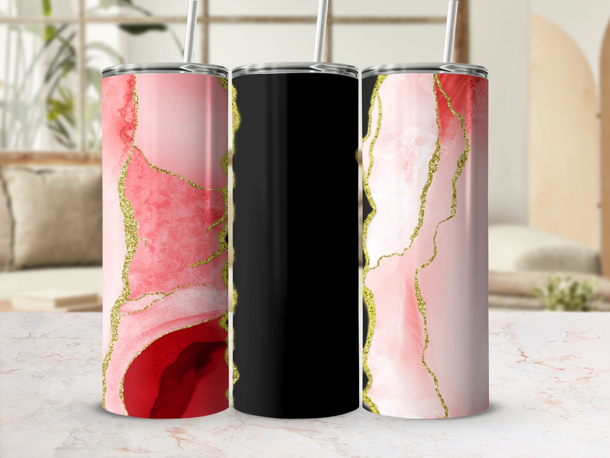 Three tumblers: two with pink and red marble patterns and gold accents, one black.