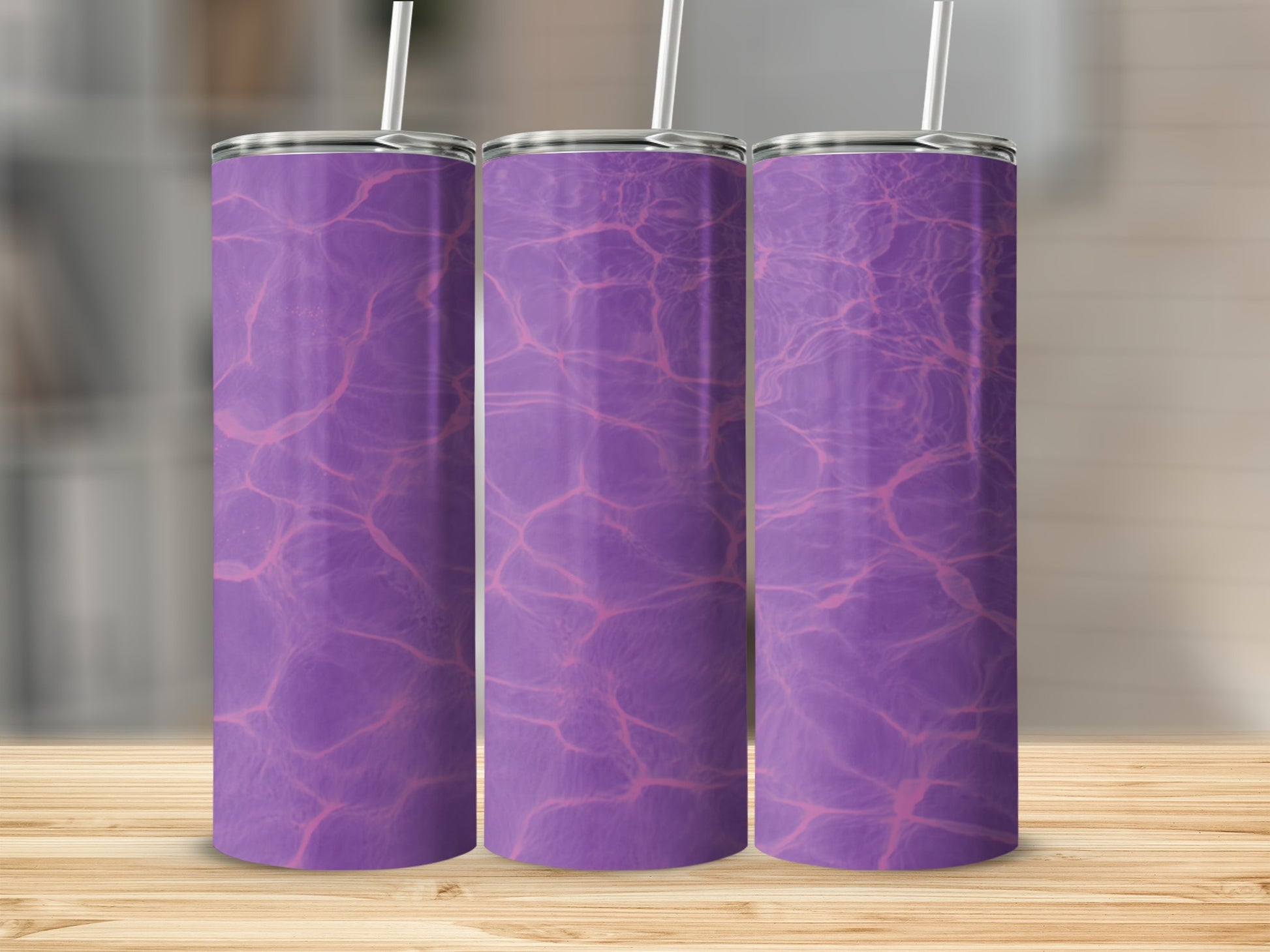 Three purple tumblers with a water ripple design on a wooden surface.
