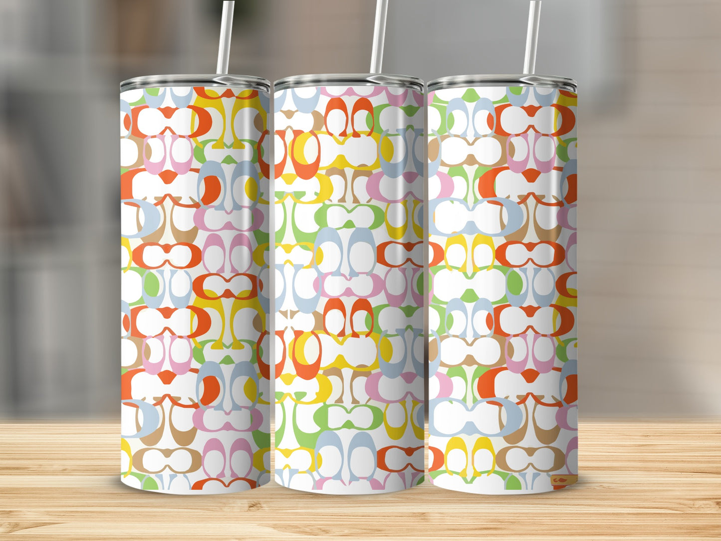 Three tumblers with colorful interlocking 'C' logo pattern and white straws.