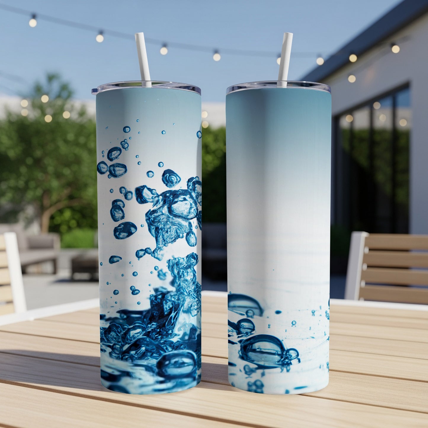 Two tumblers with splashing water design on outdoor table.