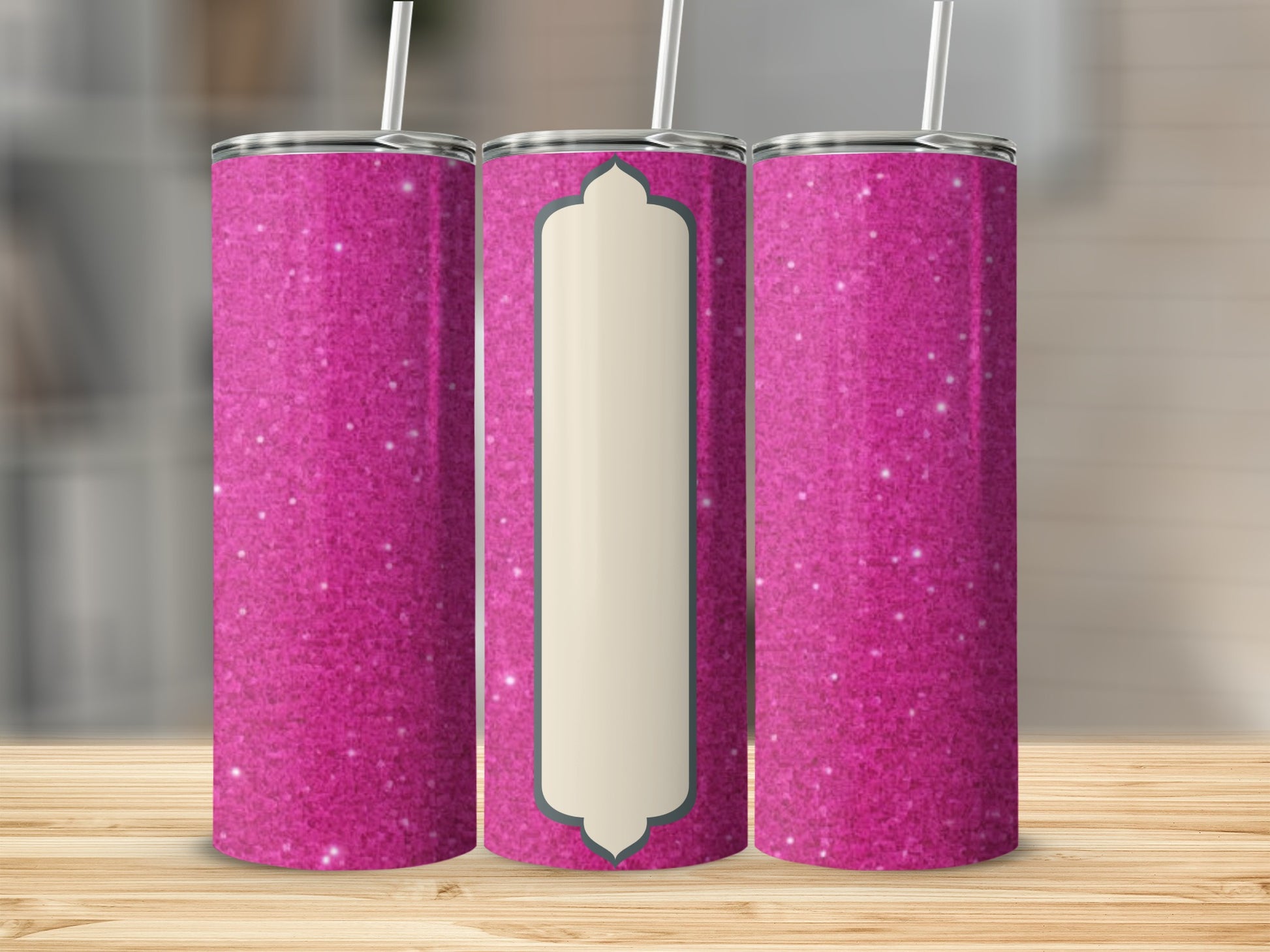 Three pink glitter tumblers with a central cream label on a wooden surface.