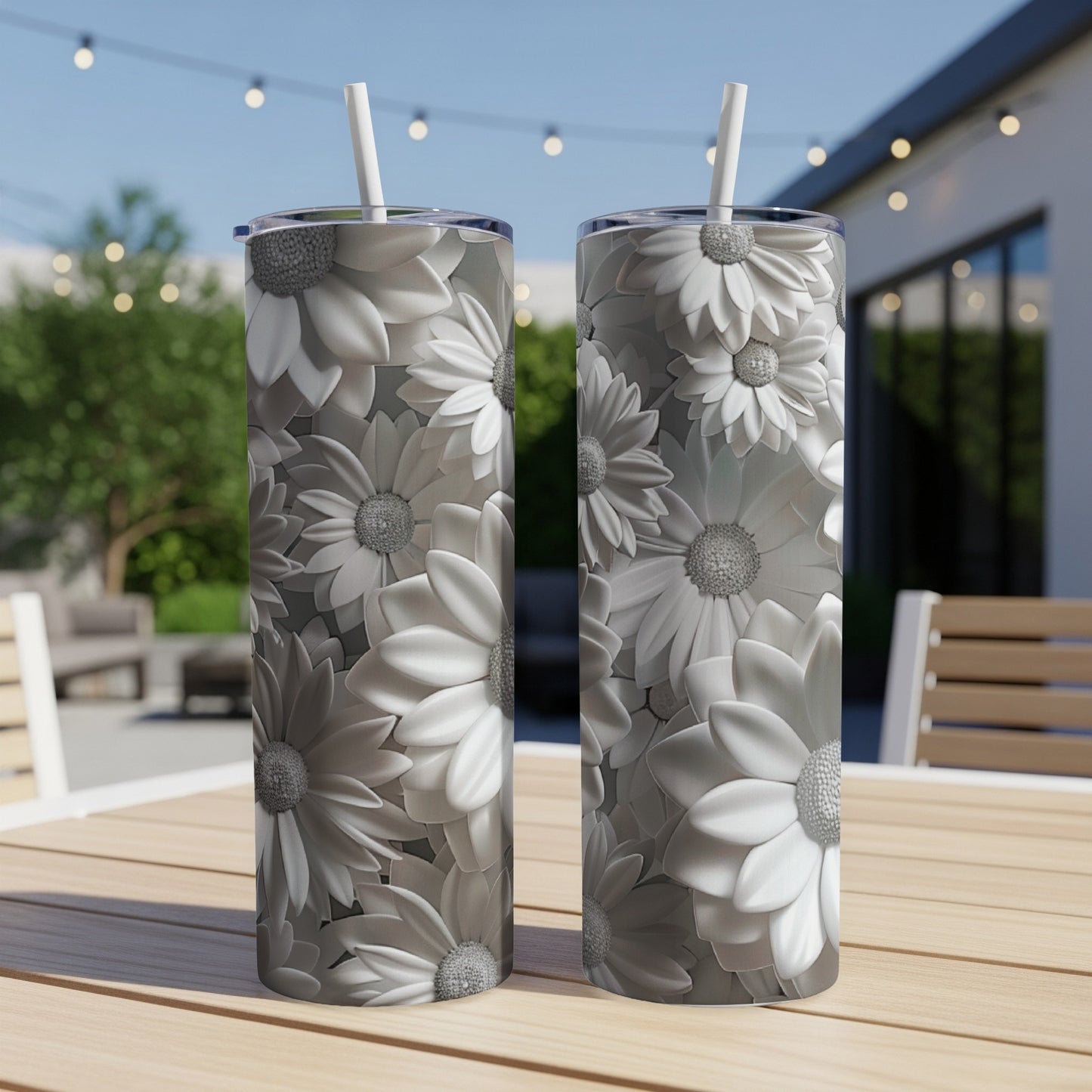 Two tall, silver tumblers with embossed floral patterns on a wooden table.