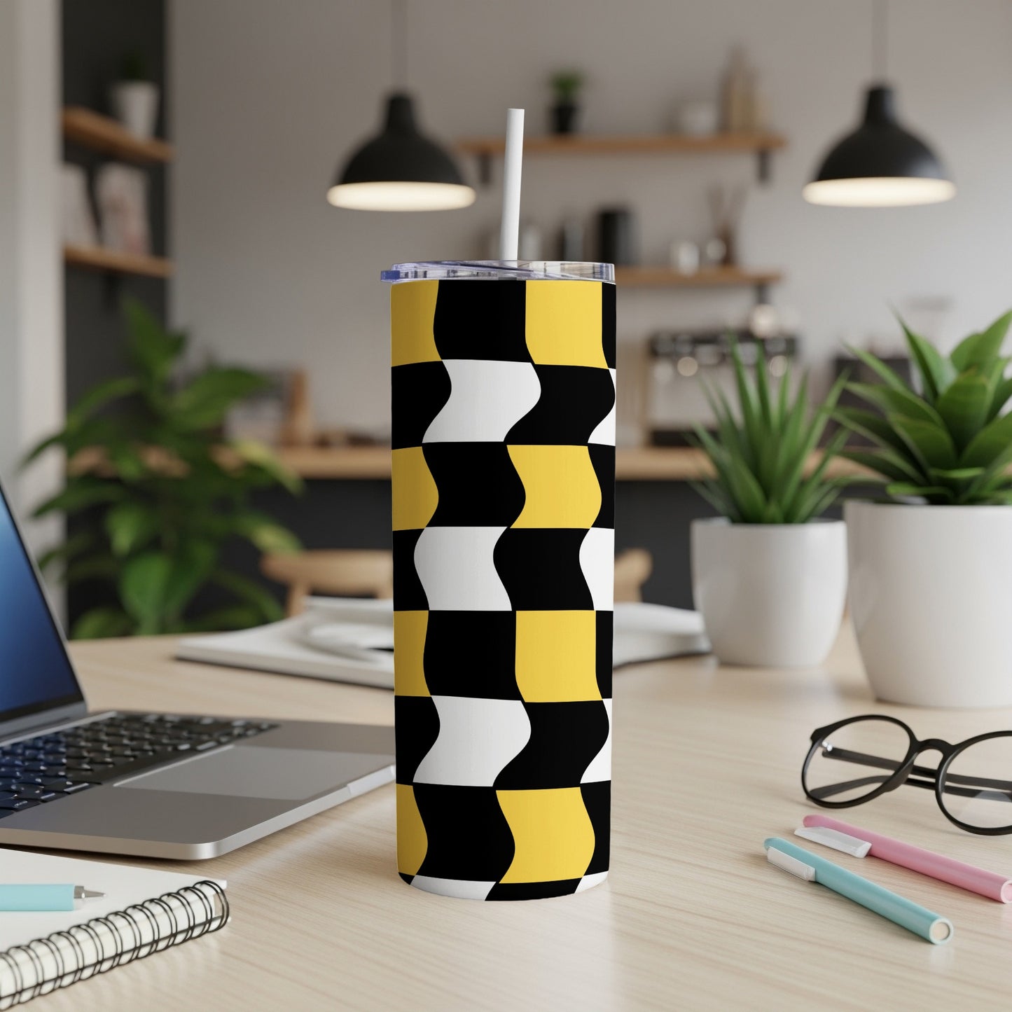 Black, white, and yellow checkered wavy pattern tumbler with straw.