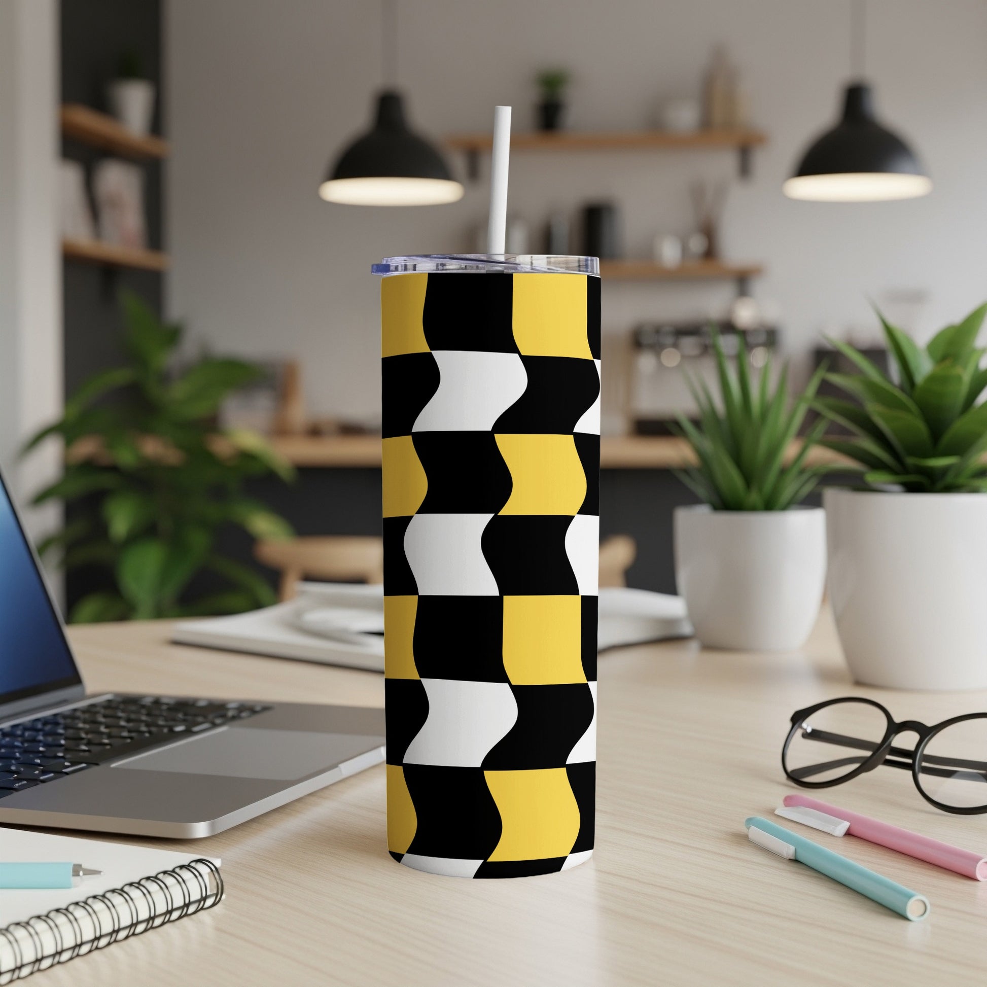 Black, white, and yellow checkered wavy pattern tumbler with straw.