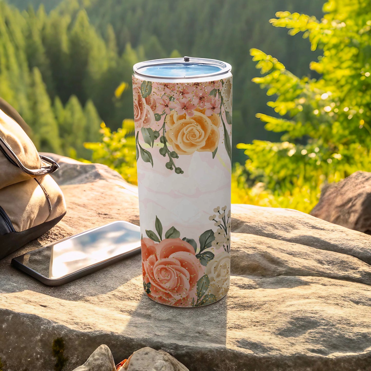 Floral tumbler with pink and orange roses on a marble background.