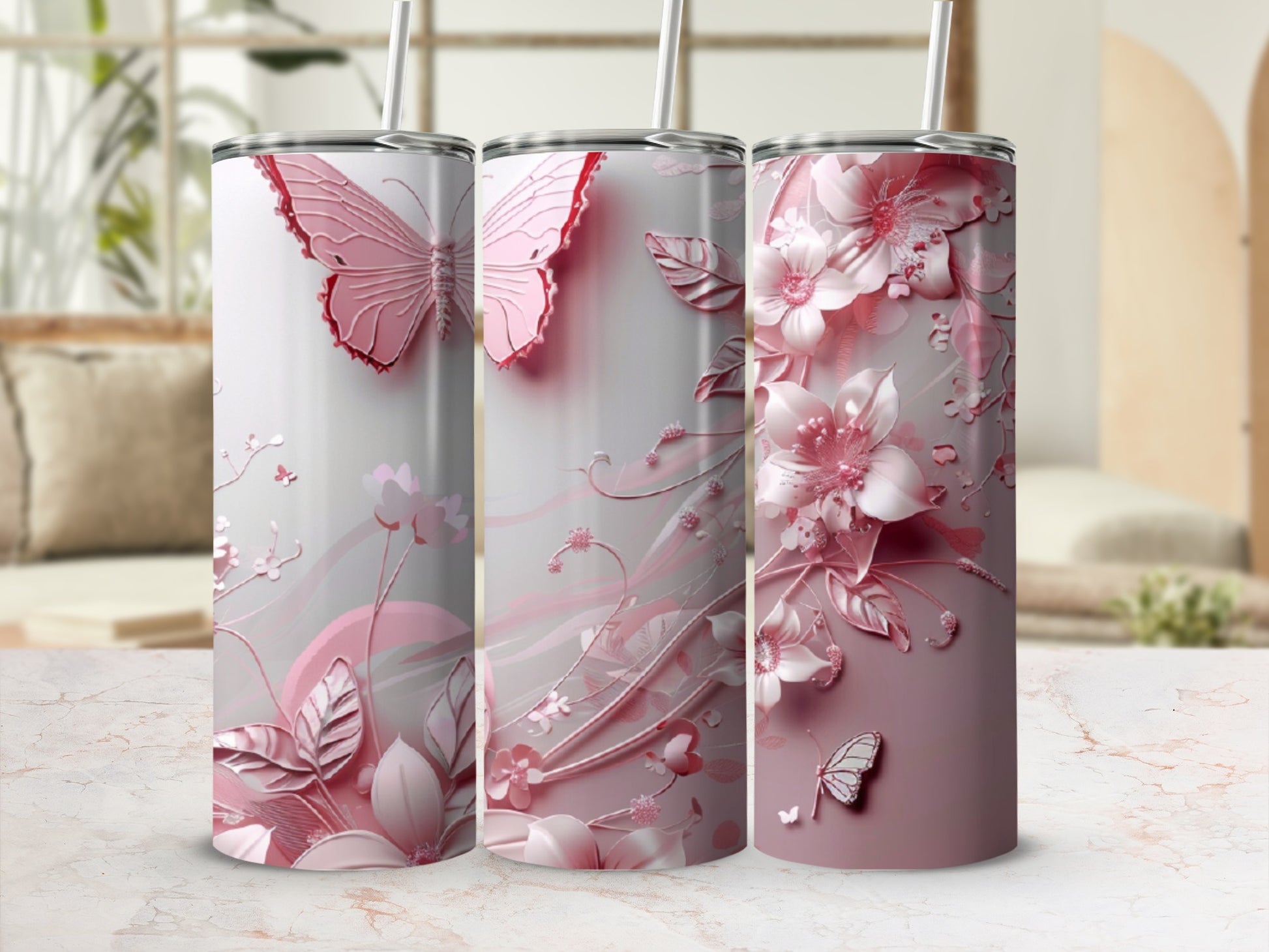 Pink floral and butterfly design on three tumblers with straws.