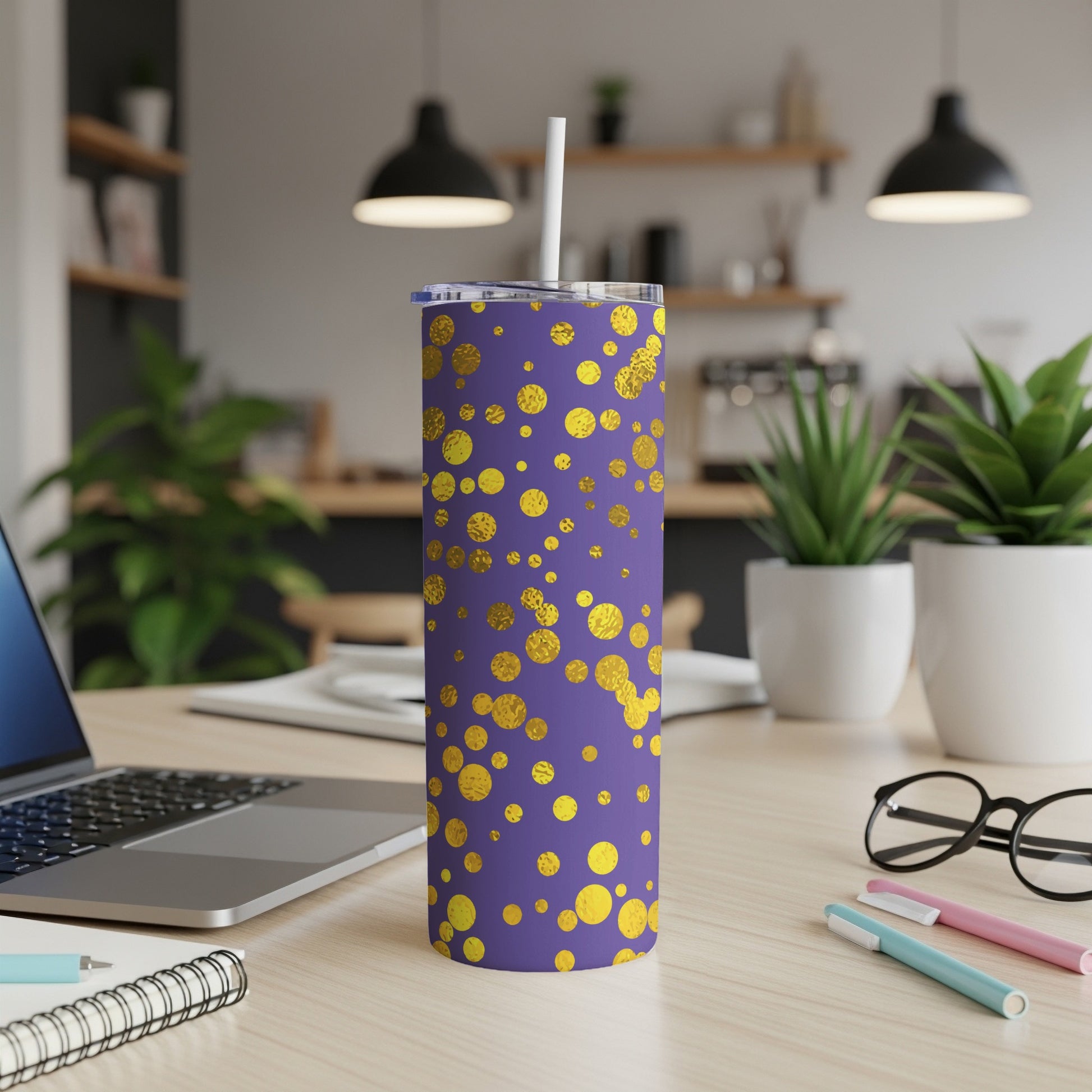 Purple tumbler with gold polka dots and white straw on a desk.