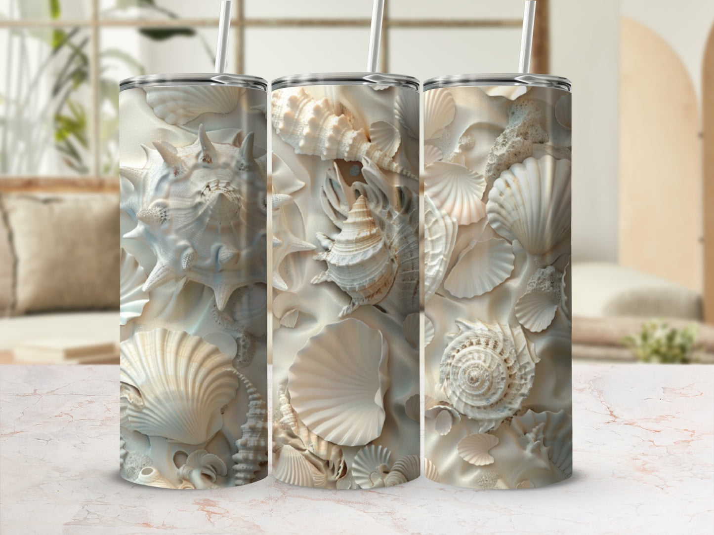 Three tumblers with intricate seashell designs and straws.
