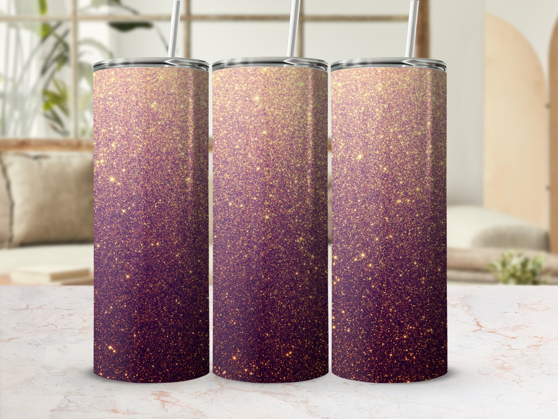 Three glittery purple and gold tumblers with straws on a marble surface.