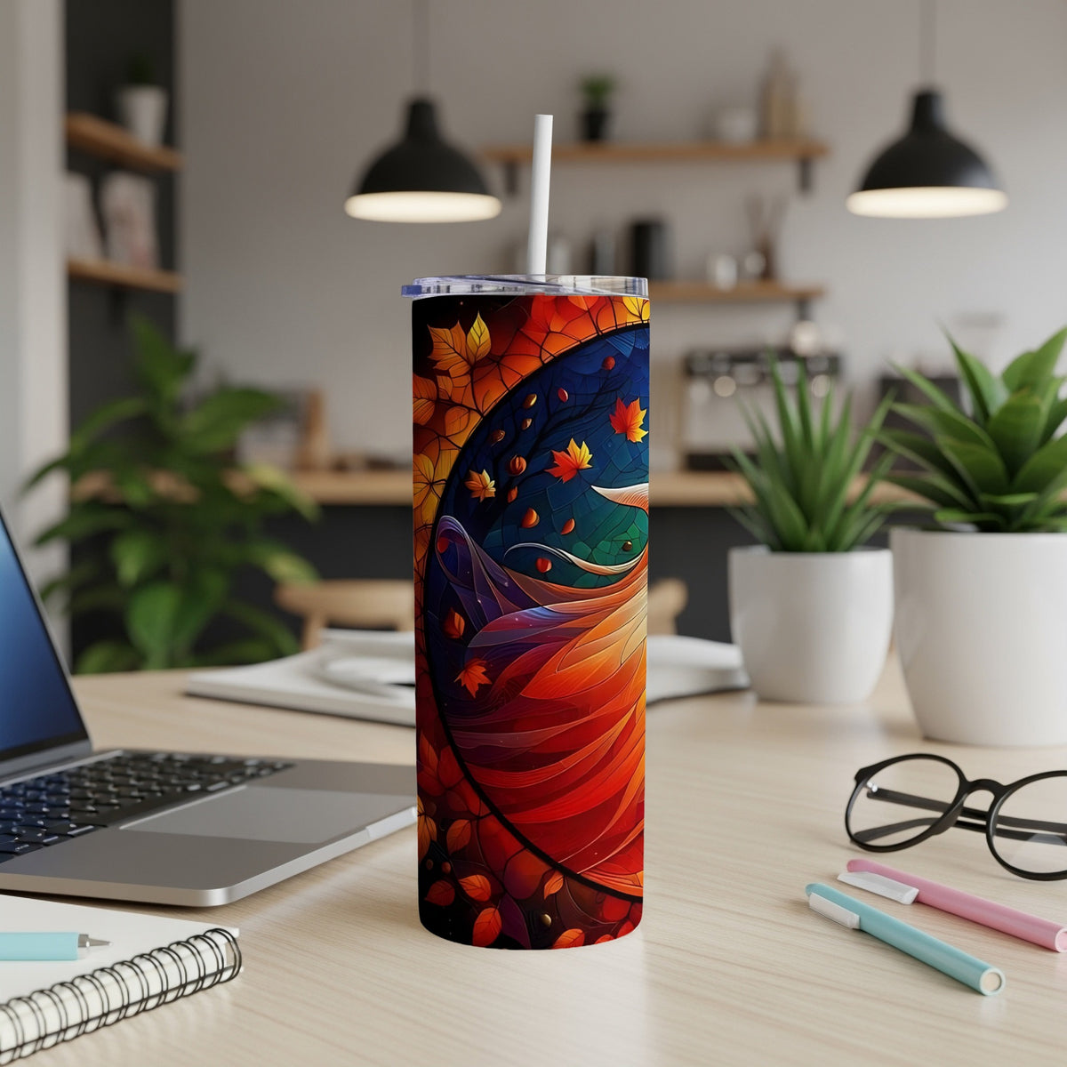 Tall tumbler with colorful autumn leaf design, straw and lid visible.