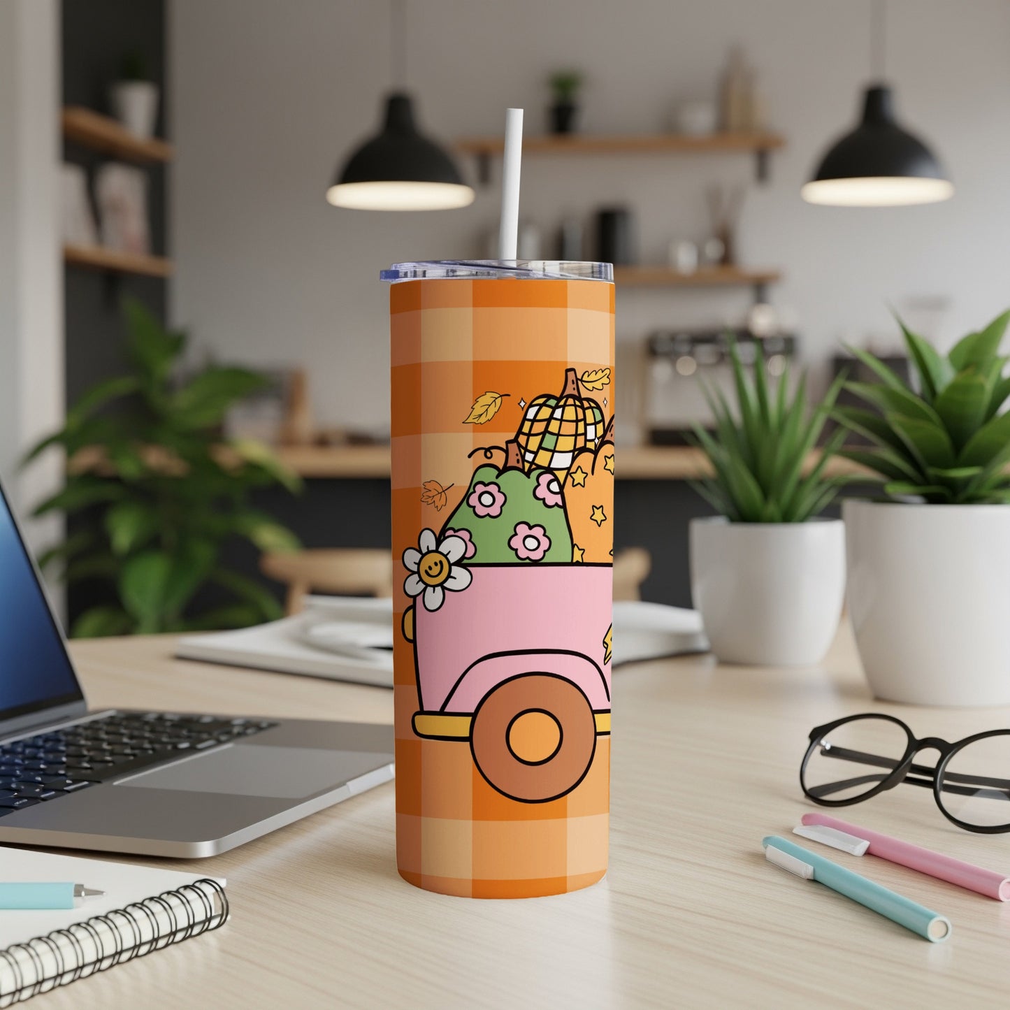 Orange tumbler with plaid pattern and a cartoon pumpkin truck with flowers.