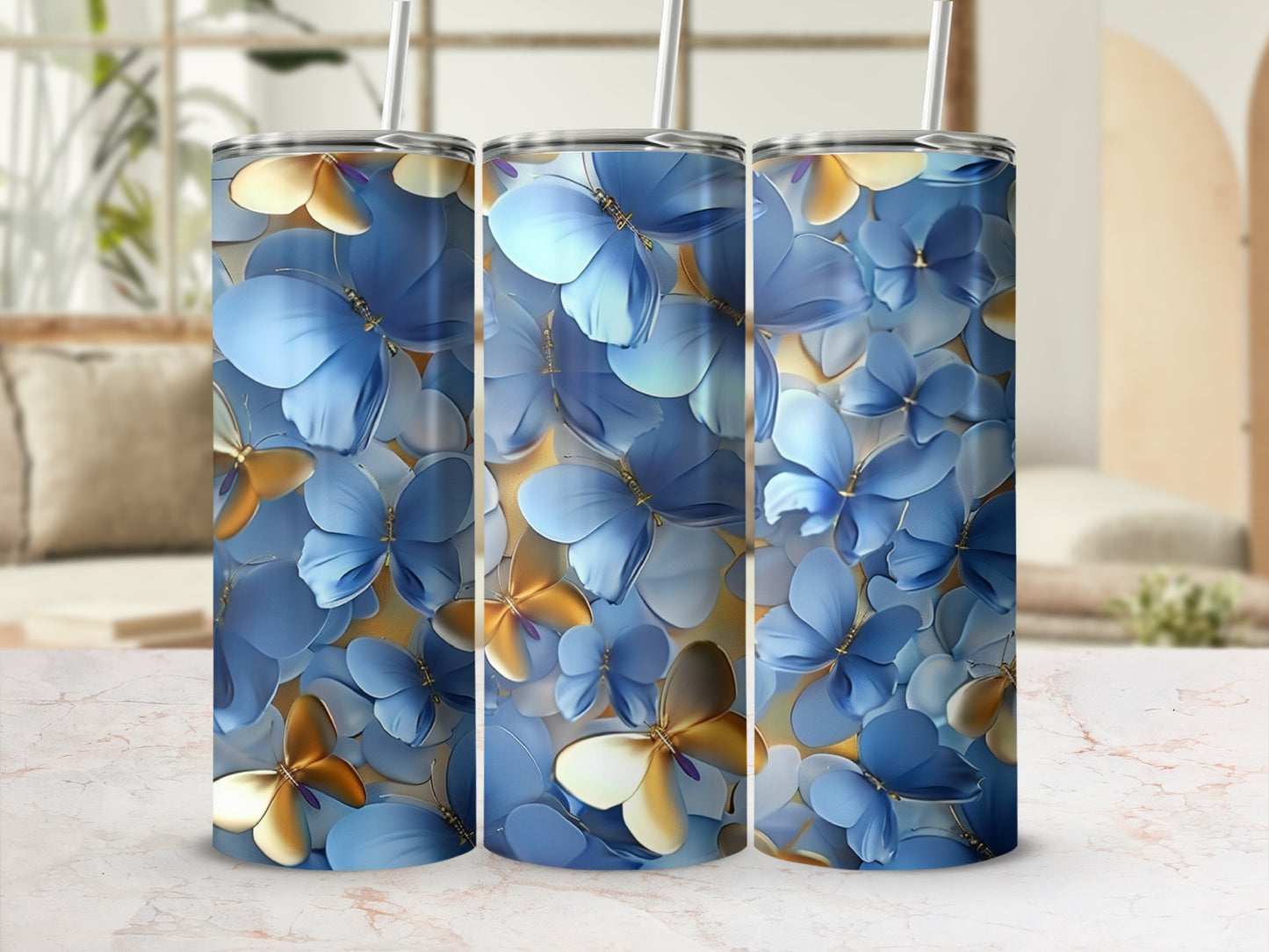 Three blue and gold butterfly pattern tumblers with straws.
