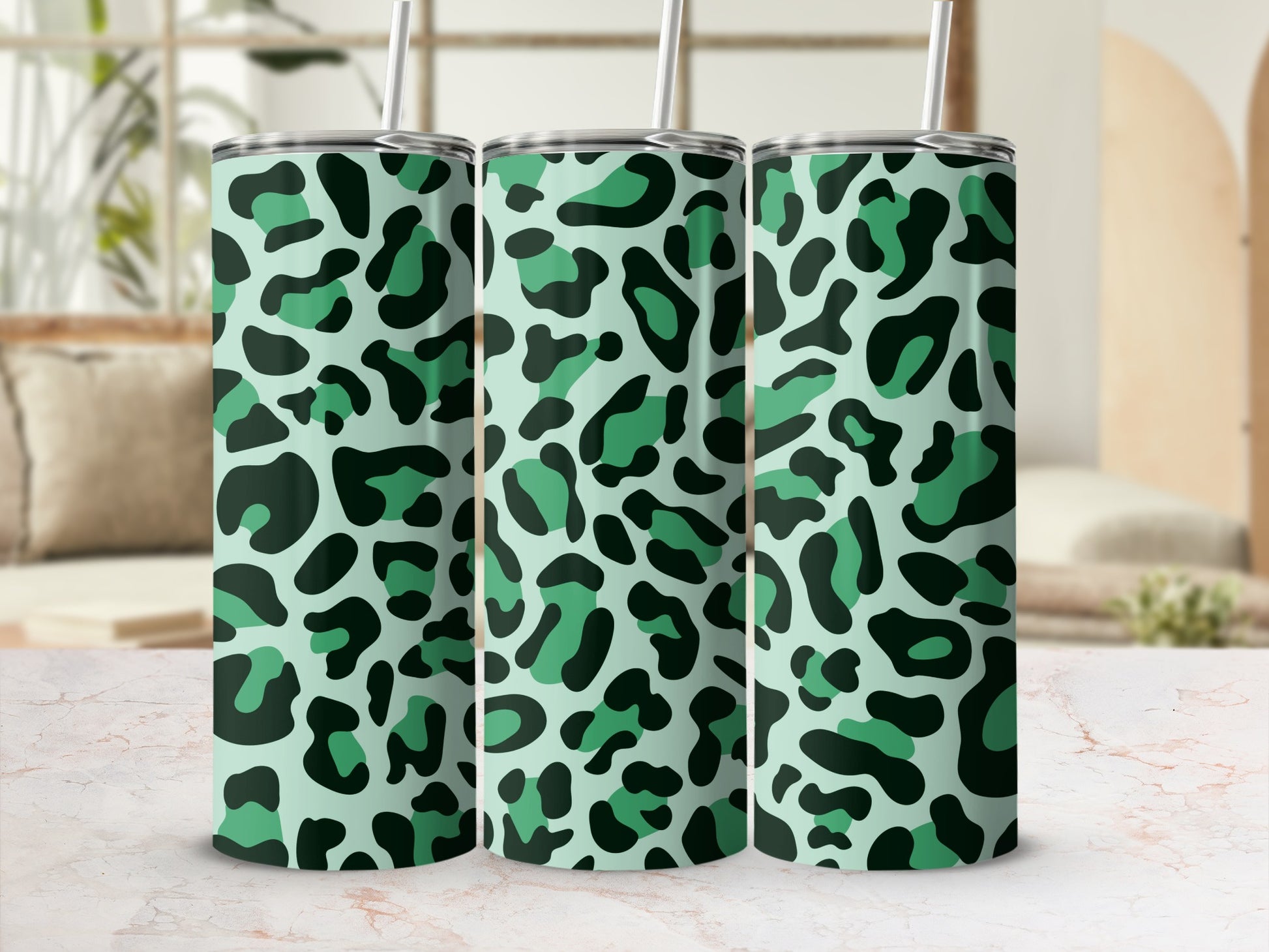 Three mint green tumblers with black and dark green leopard print and straws.