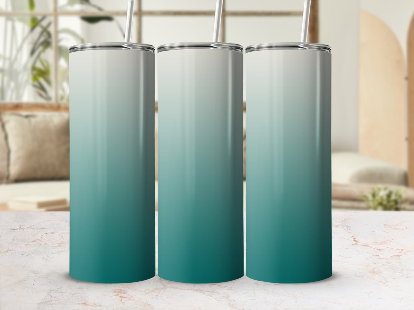 Three tumblers with a teal and white gradient design, standing on a marble countertop.