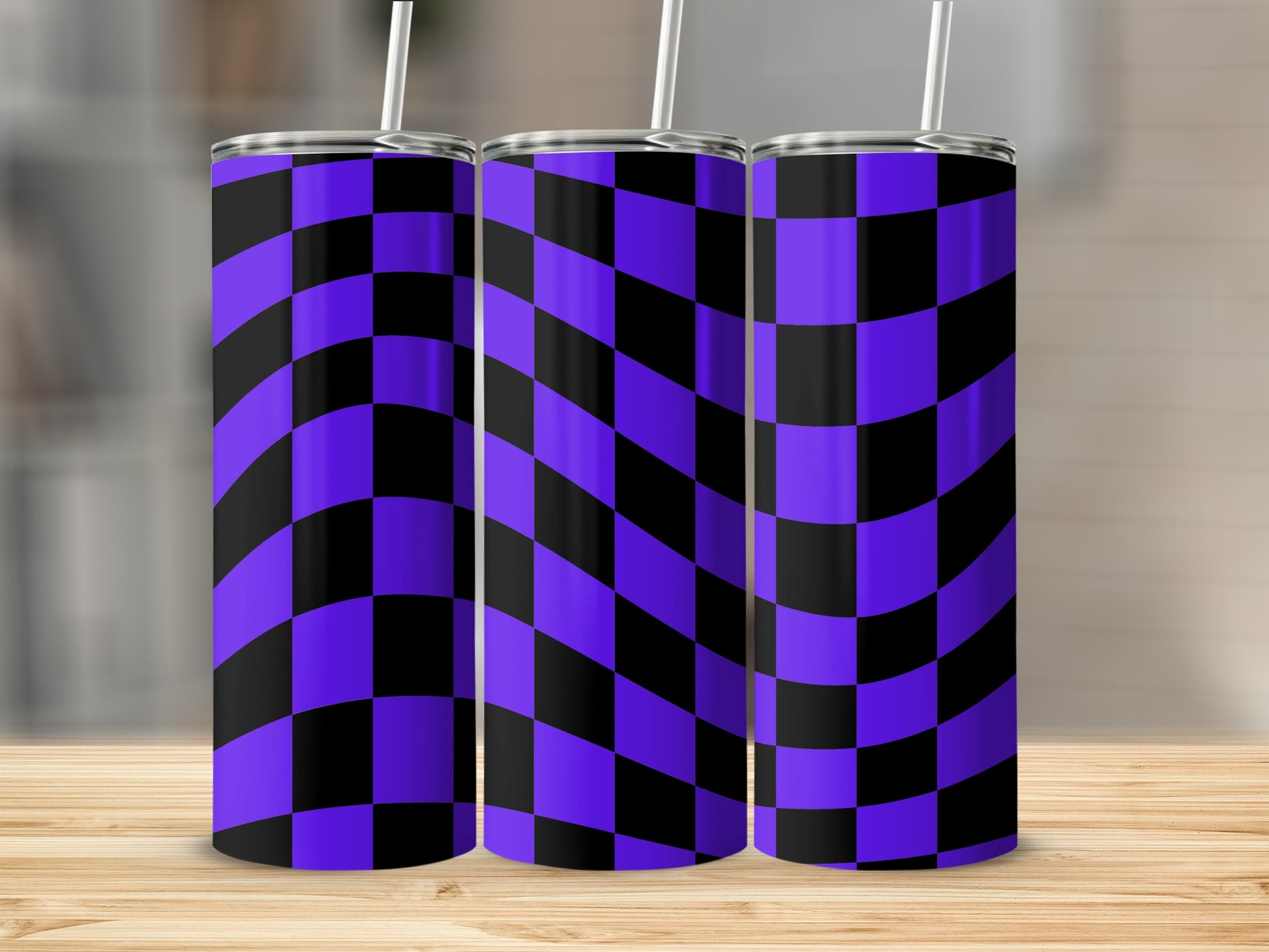 Three purple and black checkered tumblers with straws on a wooden surface.