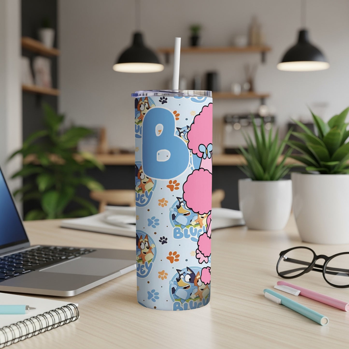 Bluey and Bingo characters on a blue patterned tumbler with white straw.