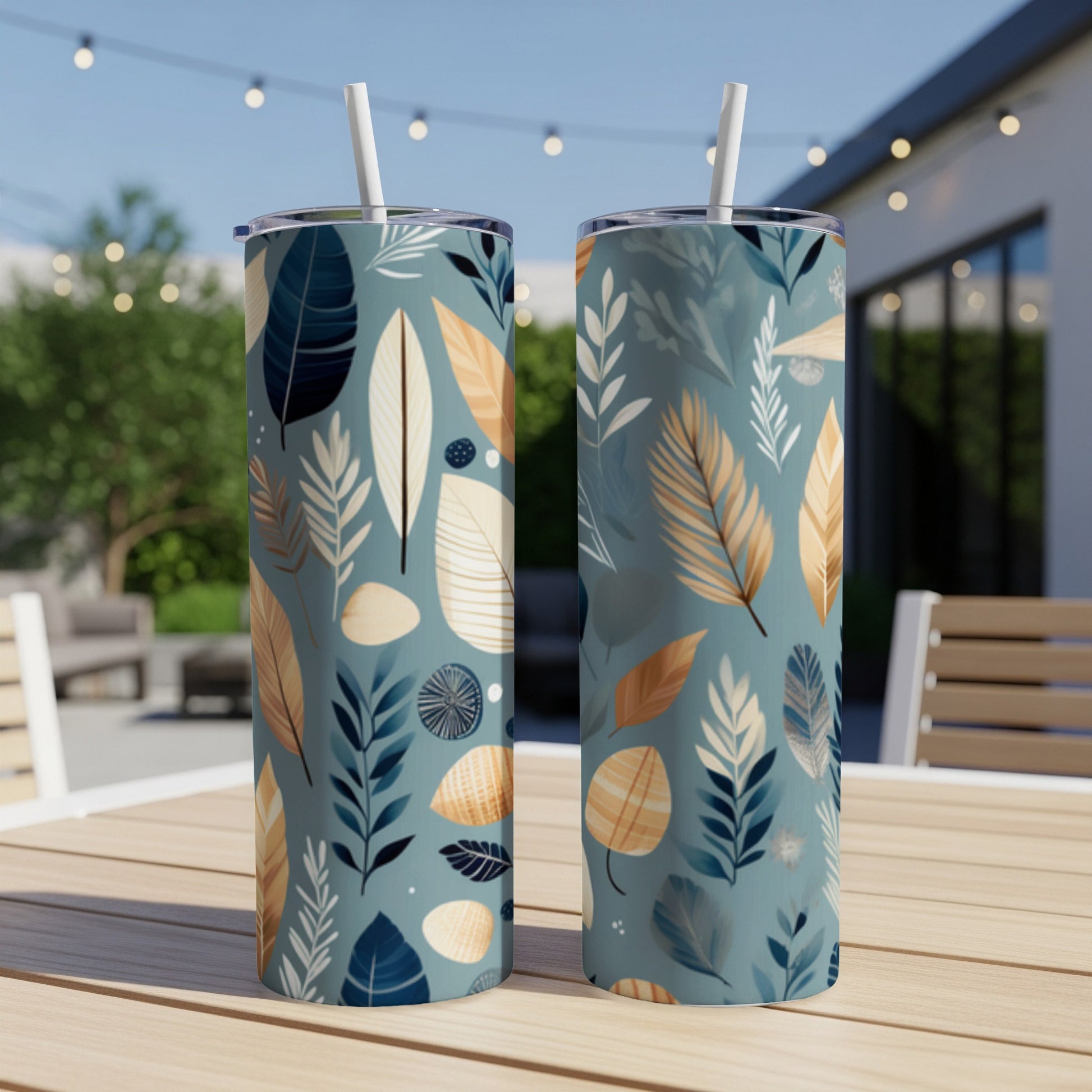 Two tumblers with a tropical leaf pattern on a wooden table.