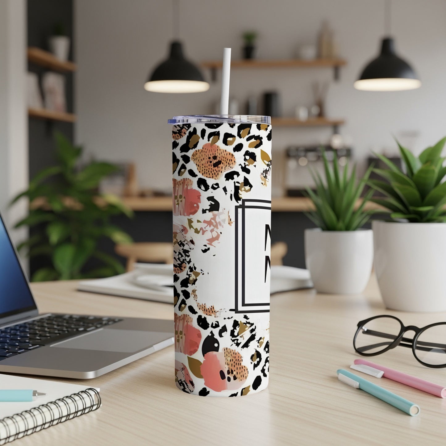 Floral and leopard print skinny tumbler with a white straw.