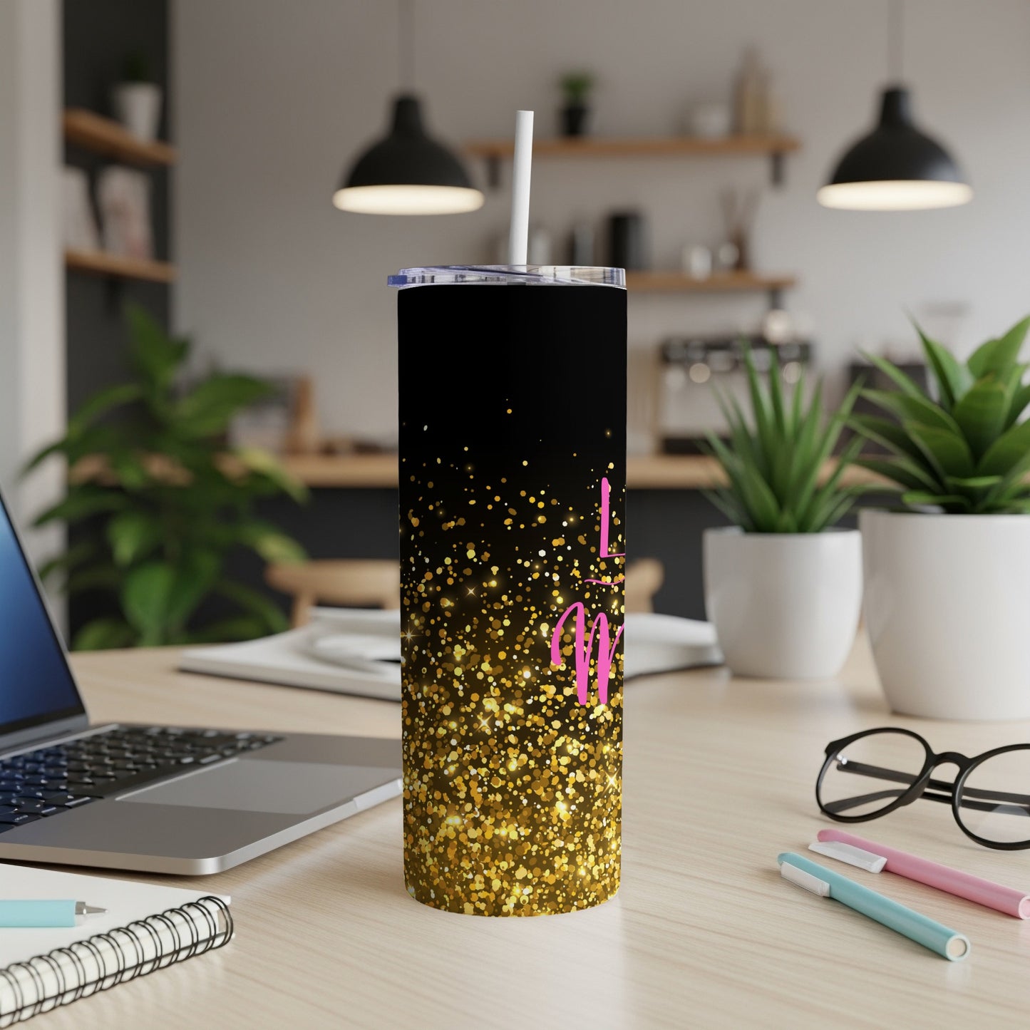 Black tumbler with gold glitter and pink "Mom" text, on a desk.