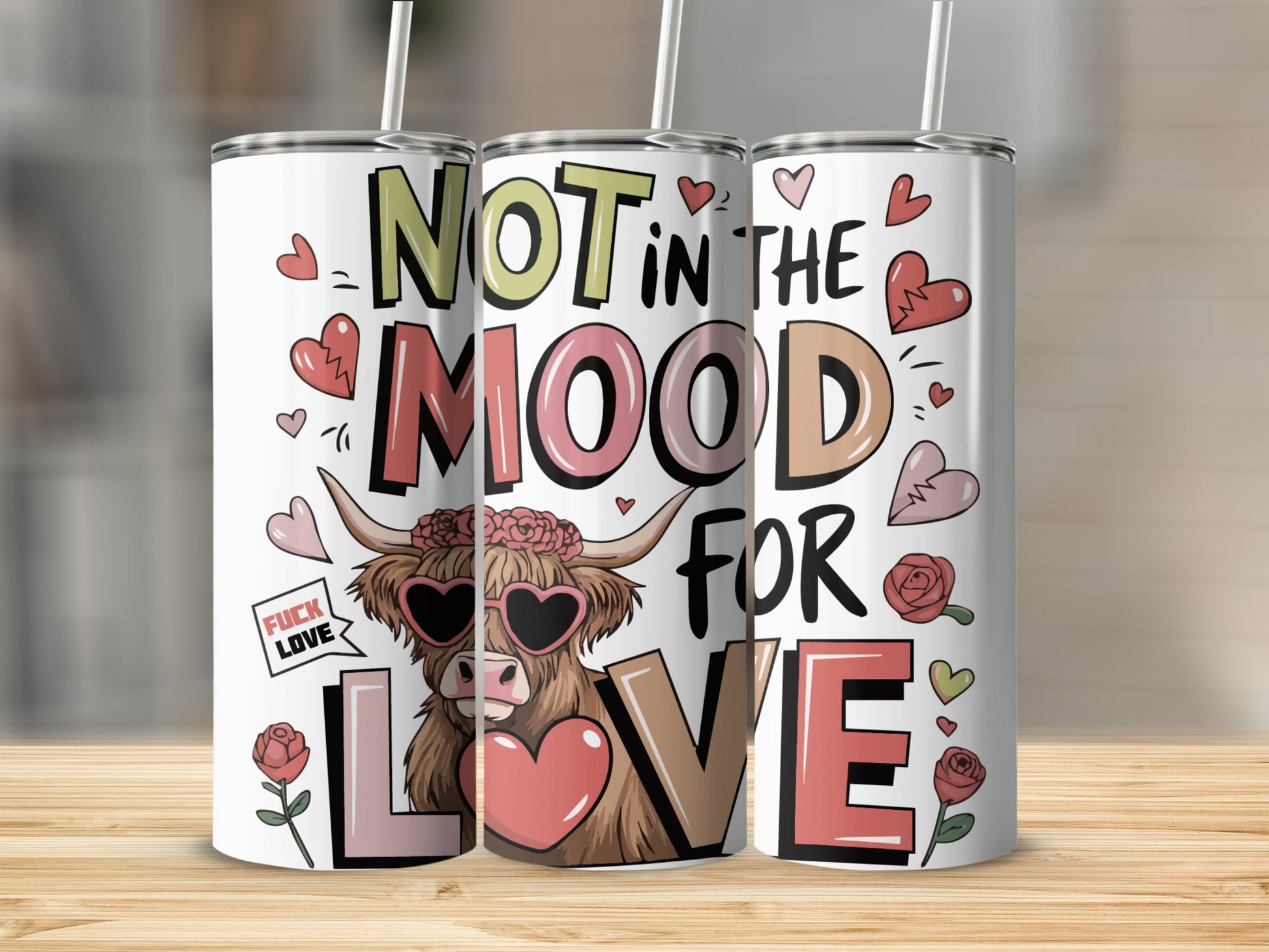 Three tumblers with "Not in the Mood for Love" text and heart and rose designs.