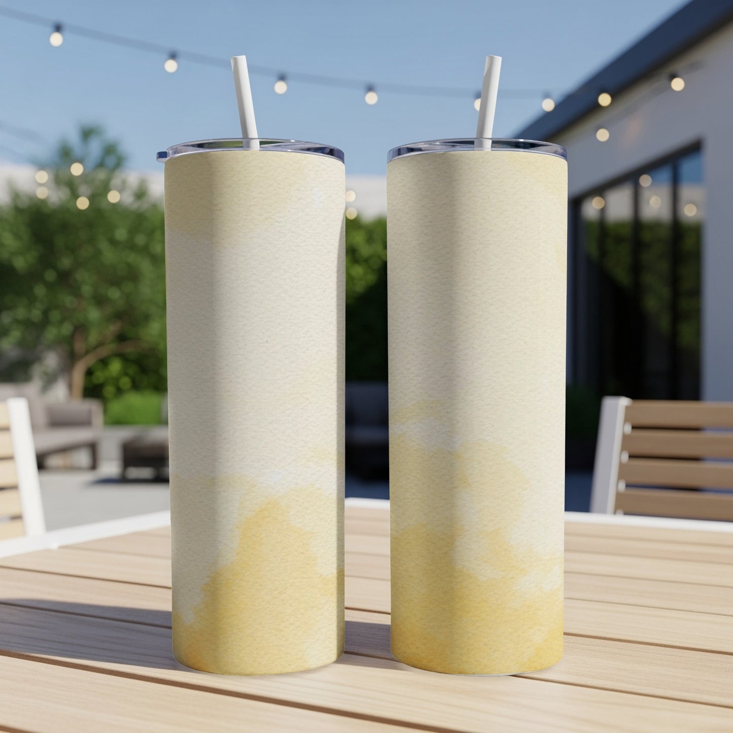 Two tall, narrow tumblers with a watercolor wash pattern sit on a wooden table.