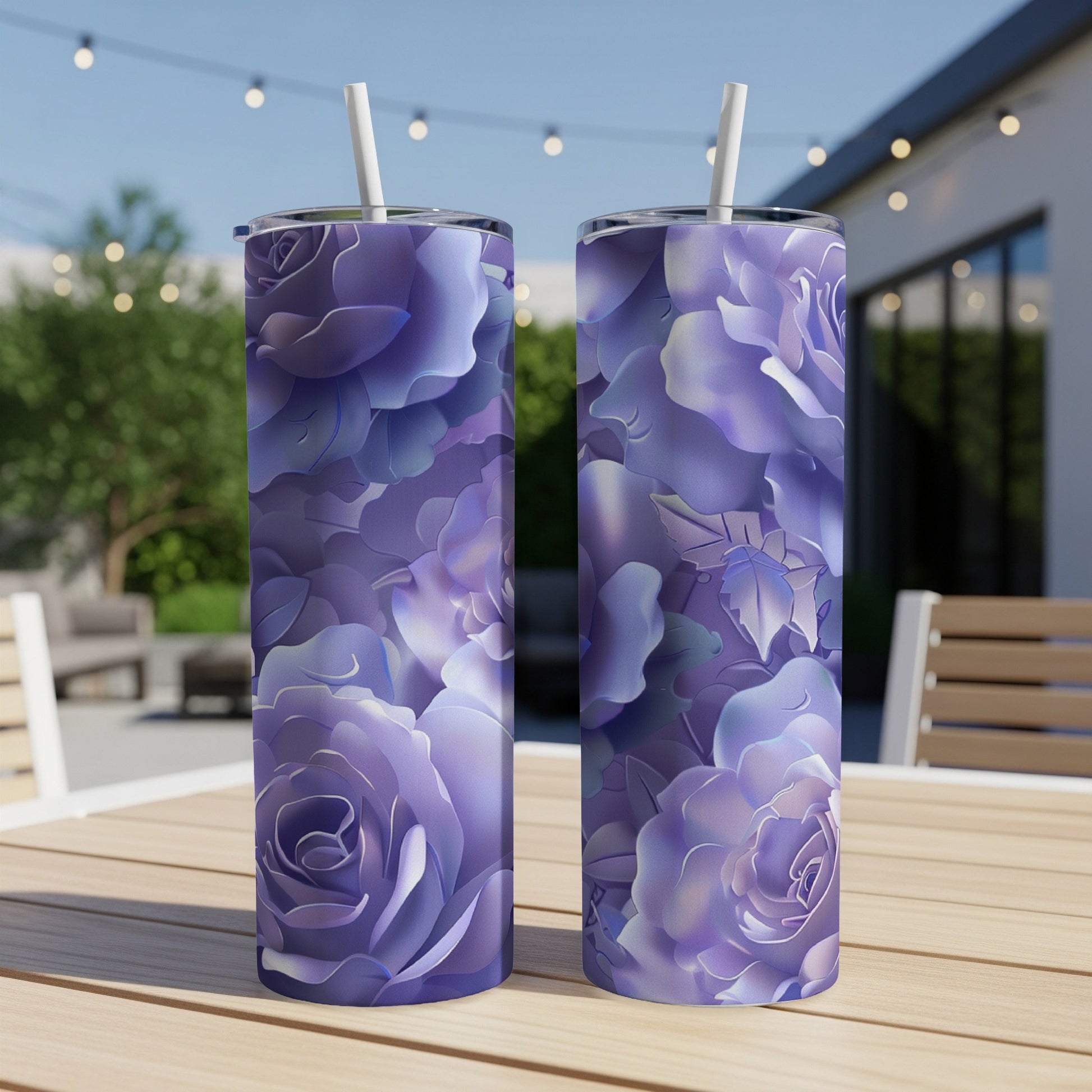 Two purple rose patterned tumblers with straws on a wooden table.
