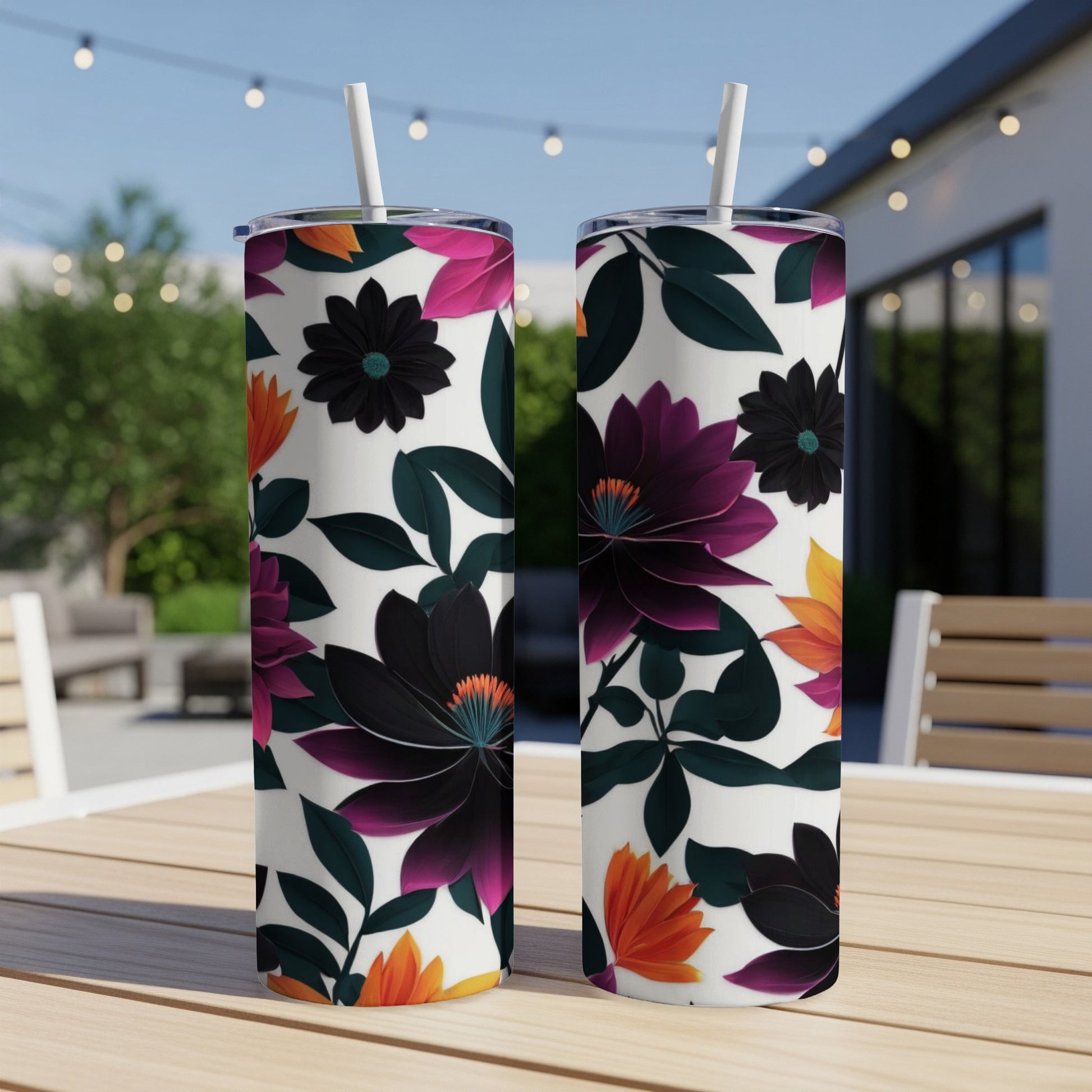 Two tumblers with a dark floral pattern on a table outdoors.