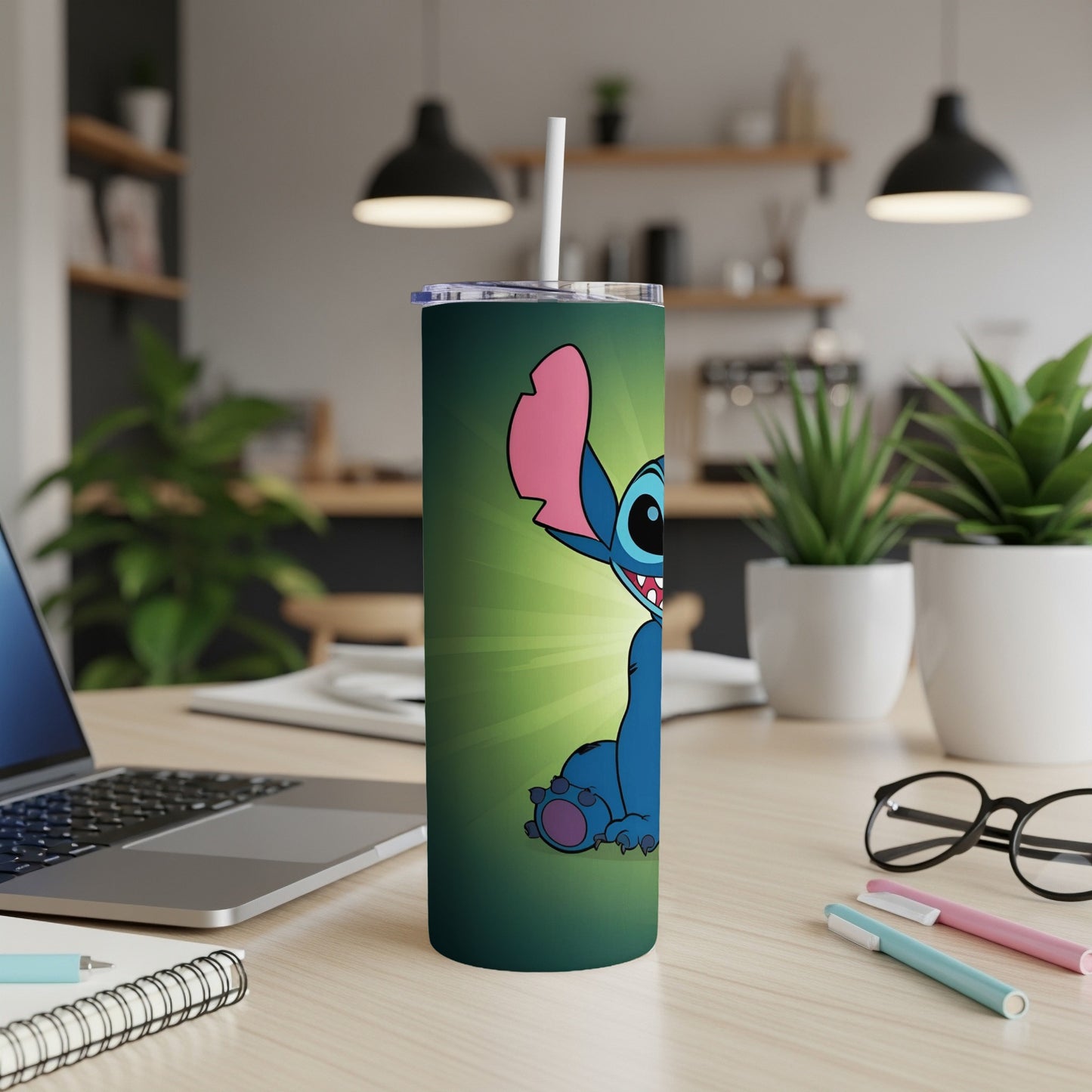 Stitch character on a dark green tumbler with a straw, placed on a desk.