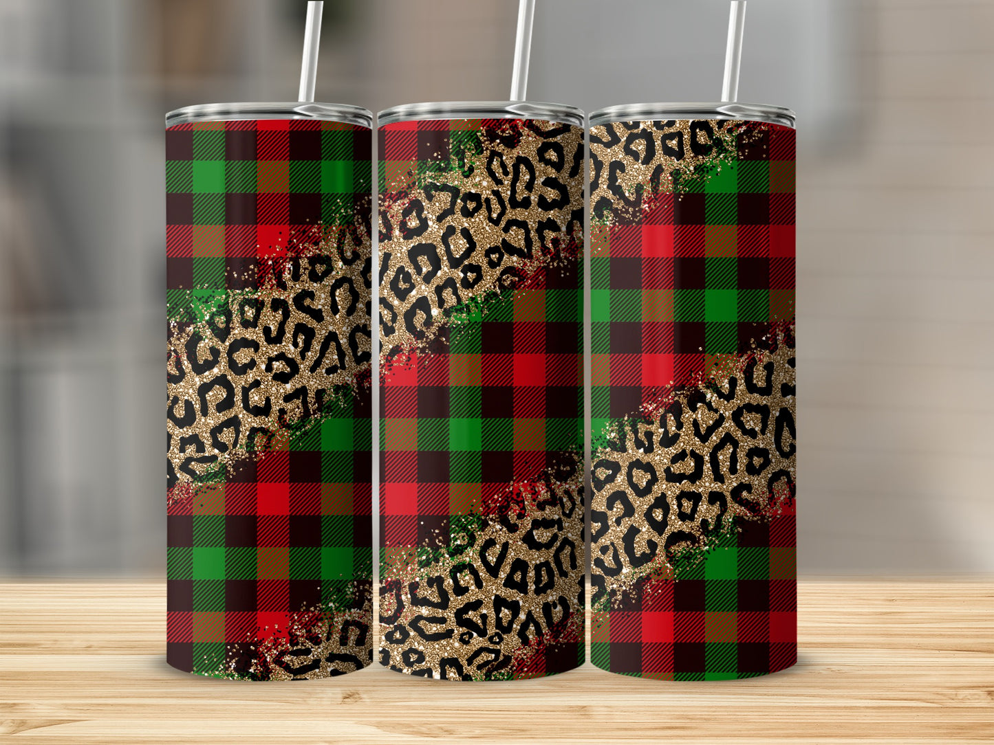 Three tumblers with plaid and leopard print designs sit on a wooden surface.