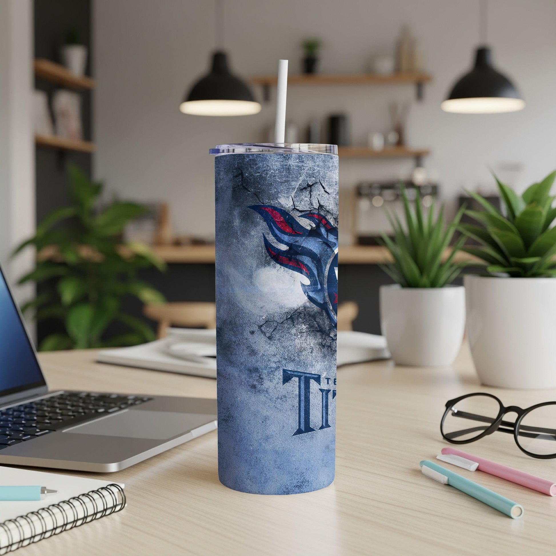 Tennessee Titans logo tumbler with a ripped blue textured design and a straw.