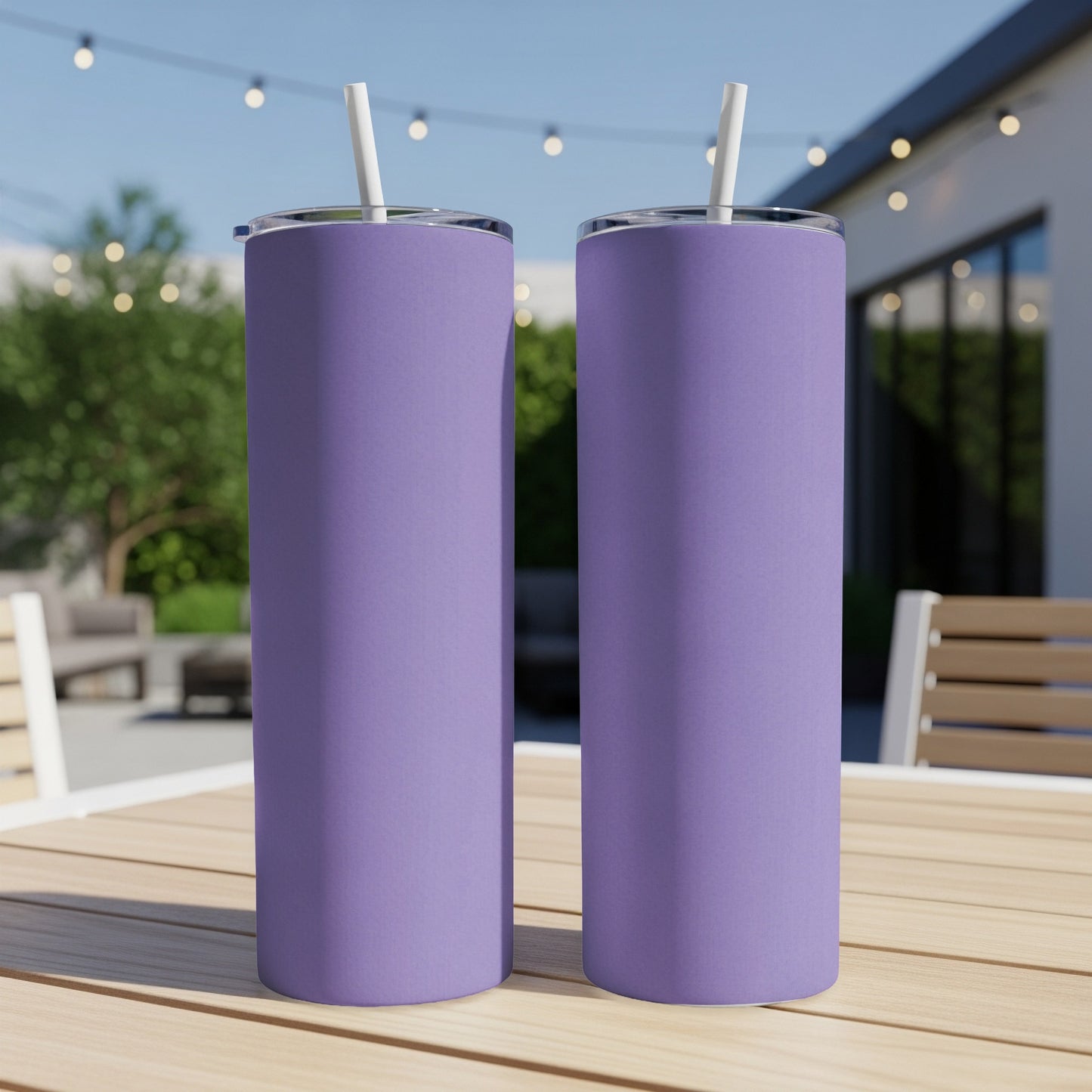 Two tall, purple tumblers with straws sit on a wooden table outdoors.