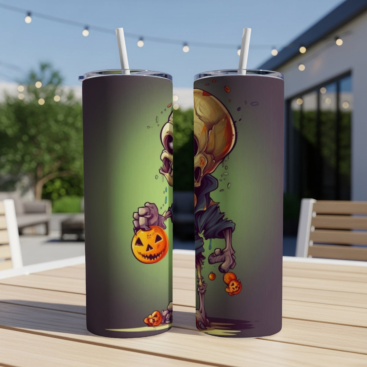 Two tumblers with a cartoon skeleton holding a jack-o'-lantern on a wooden table.