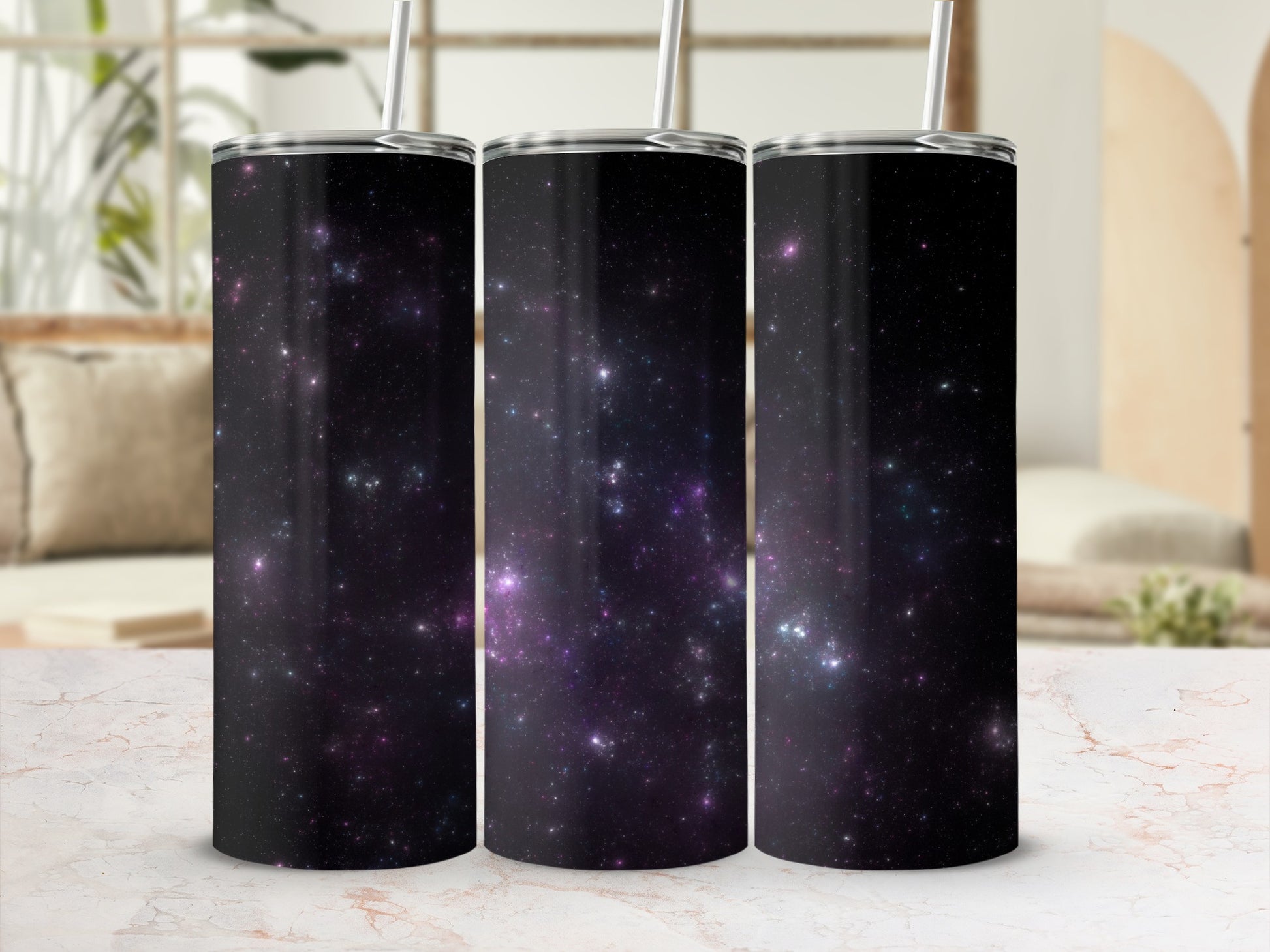 Three tumblers with a black, star-filled galaxy pattern and silver straws.