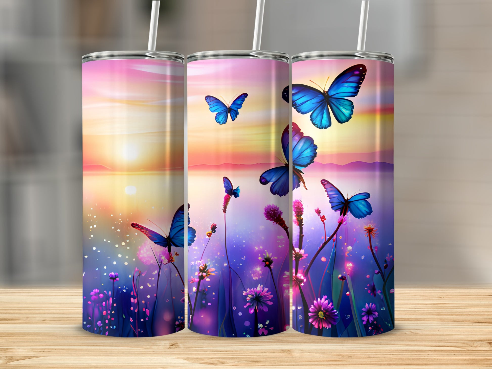 Three tumblers with butterflies and a sunset scene.
