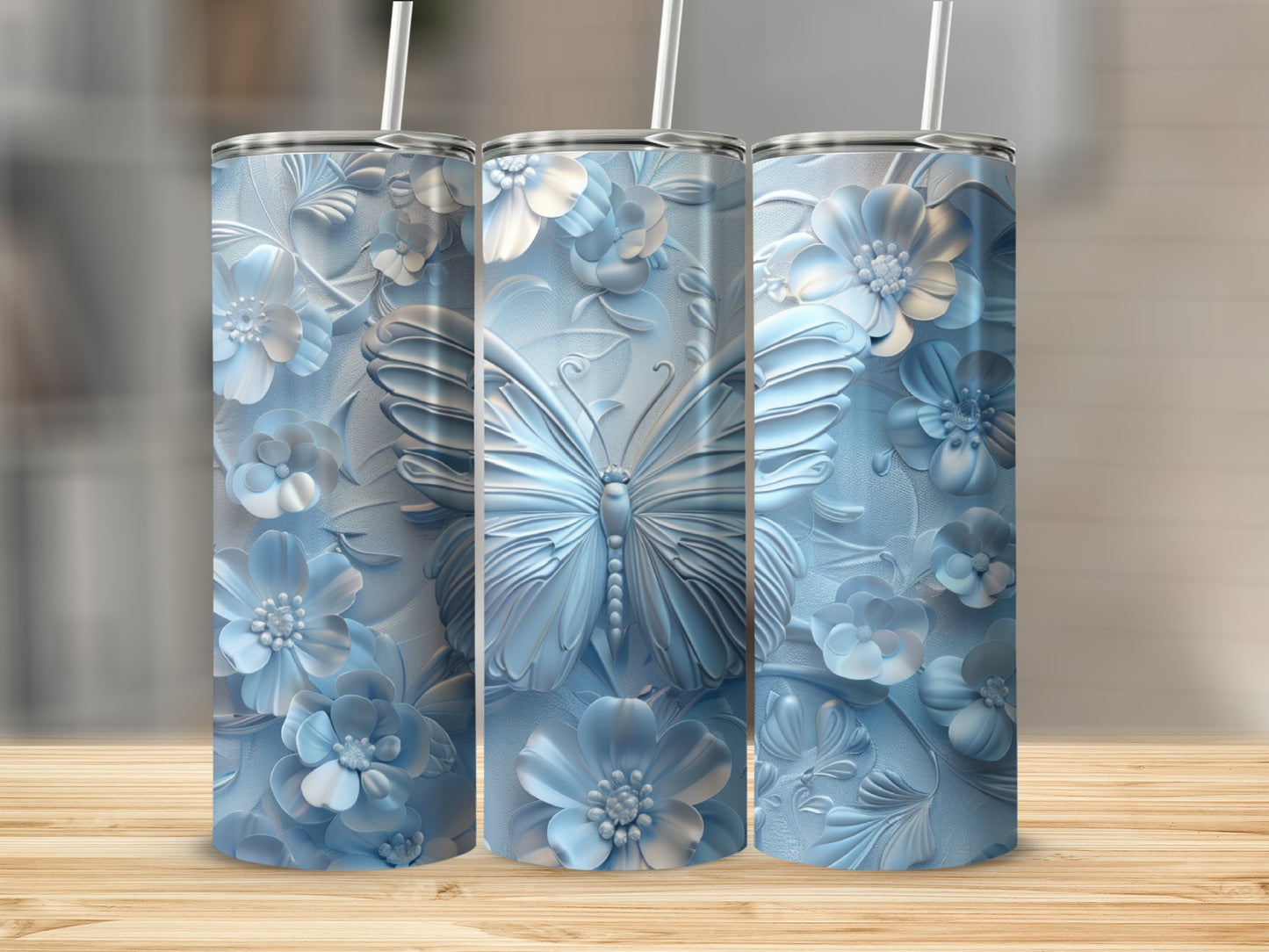 Three pastel blue tumblers with raised floral and butterfly designs.