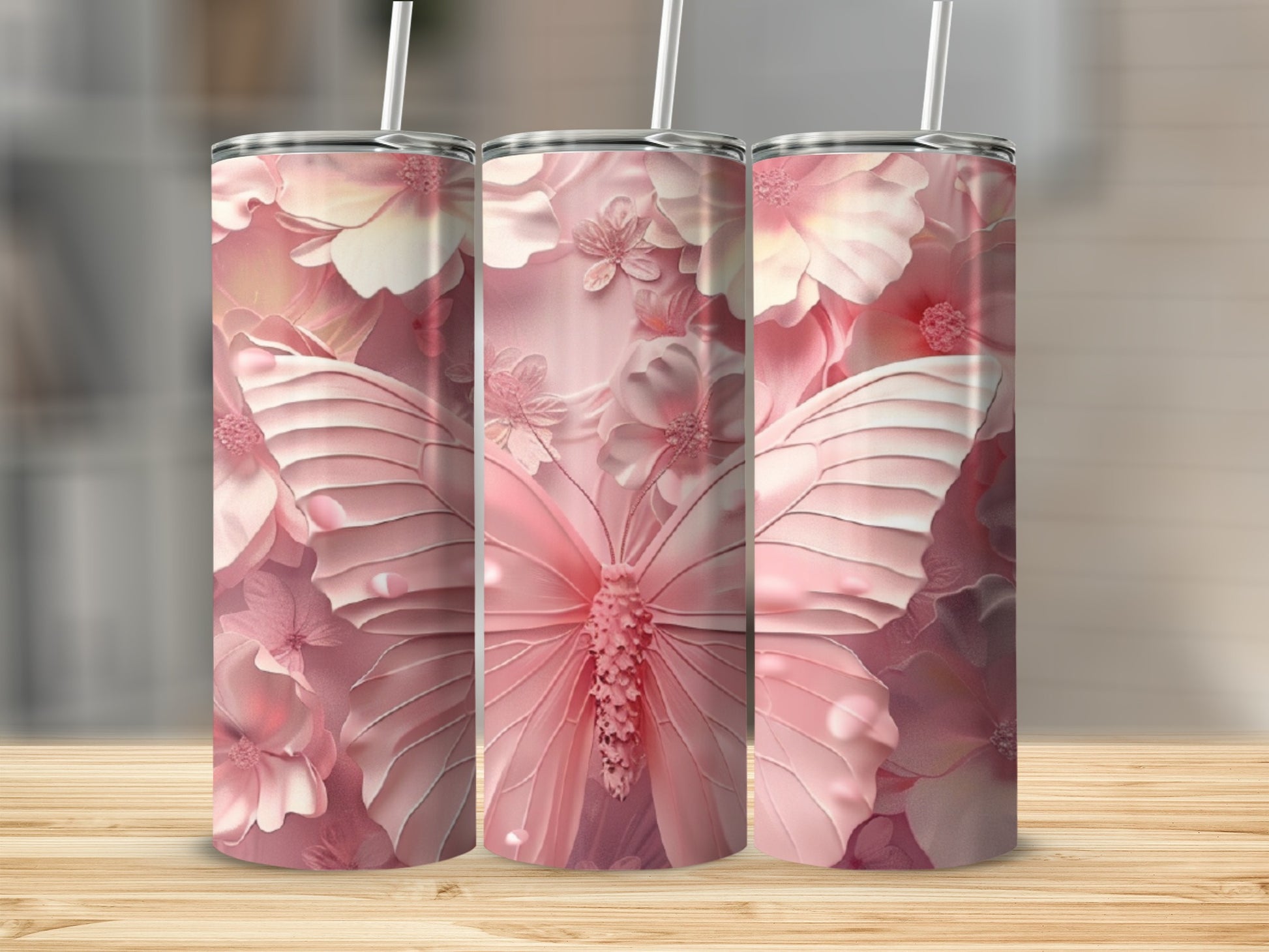 Three pink butterfly tumblers with floral patterns on a wooden surface.