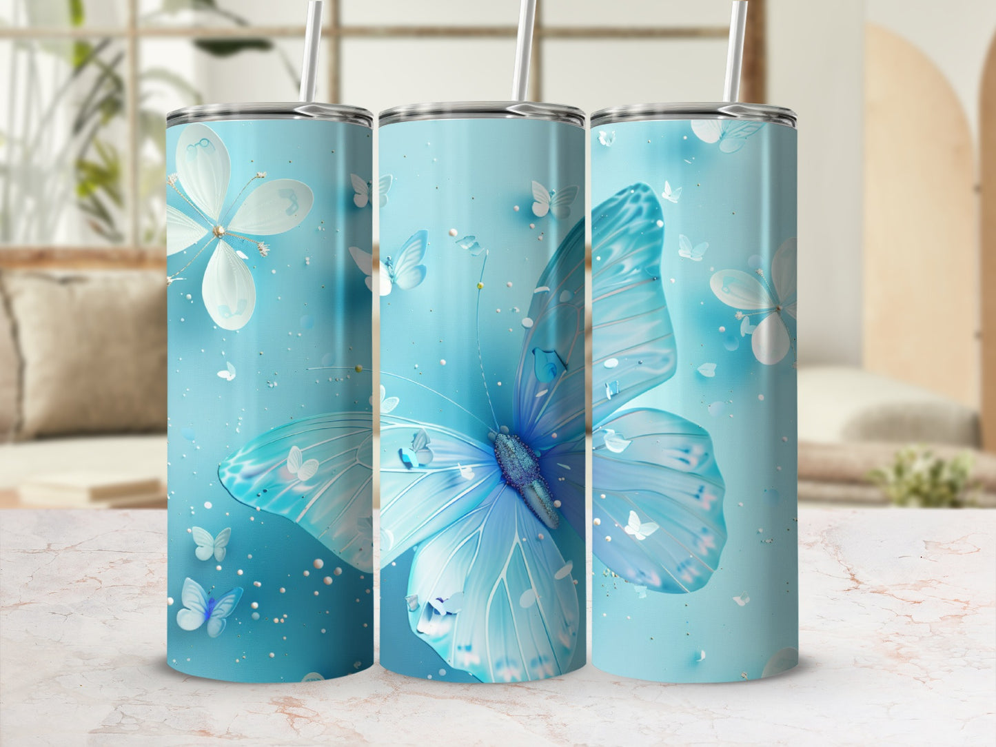 Three blue tumblers with iridescent butterflies and scattered glitter.