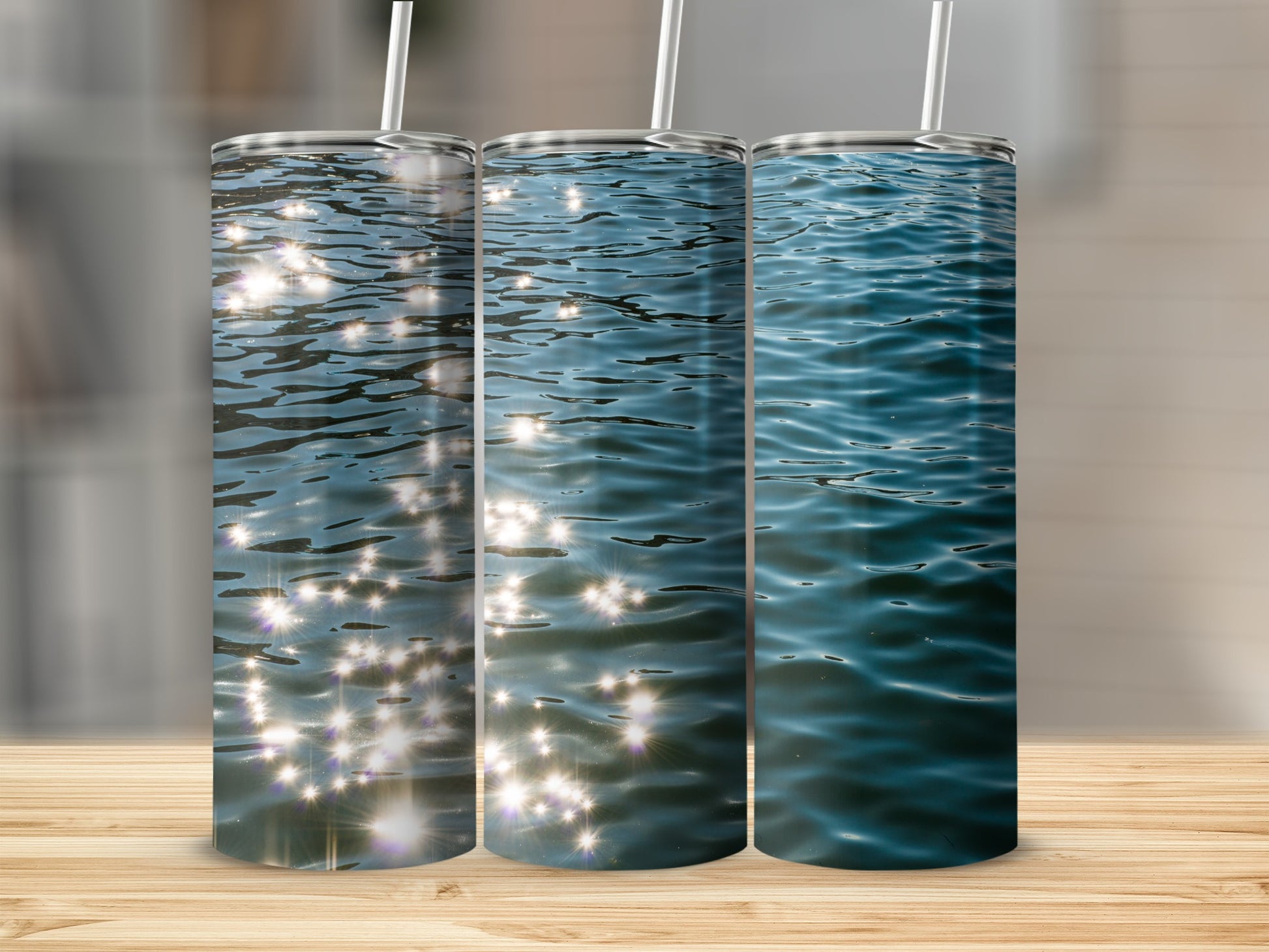 Three tumblers displaying shimmering sunlight on rippling blue water.