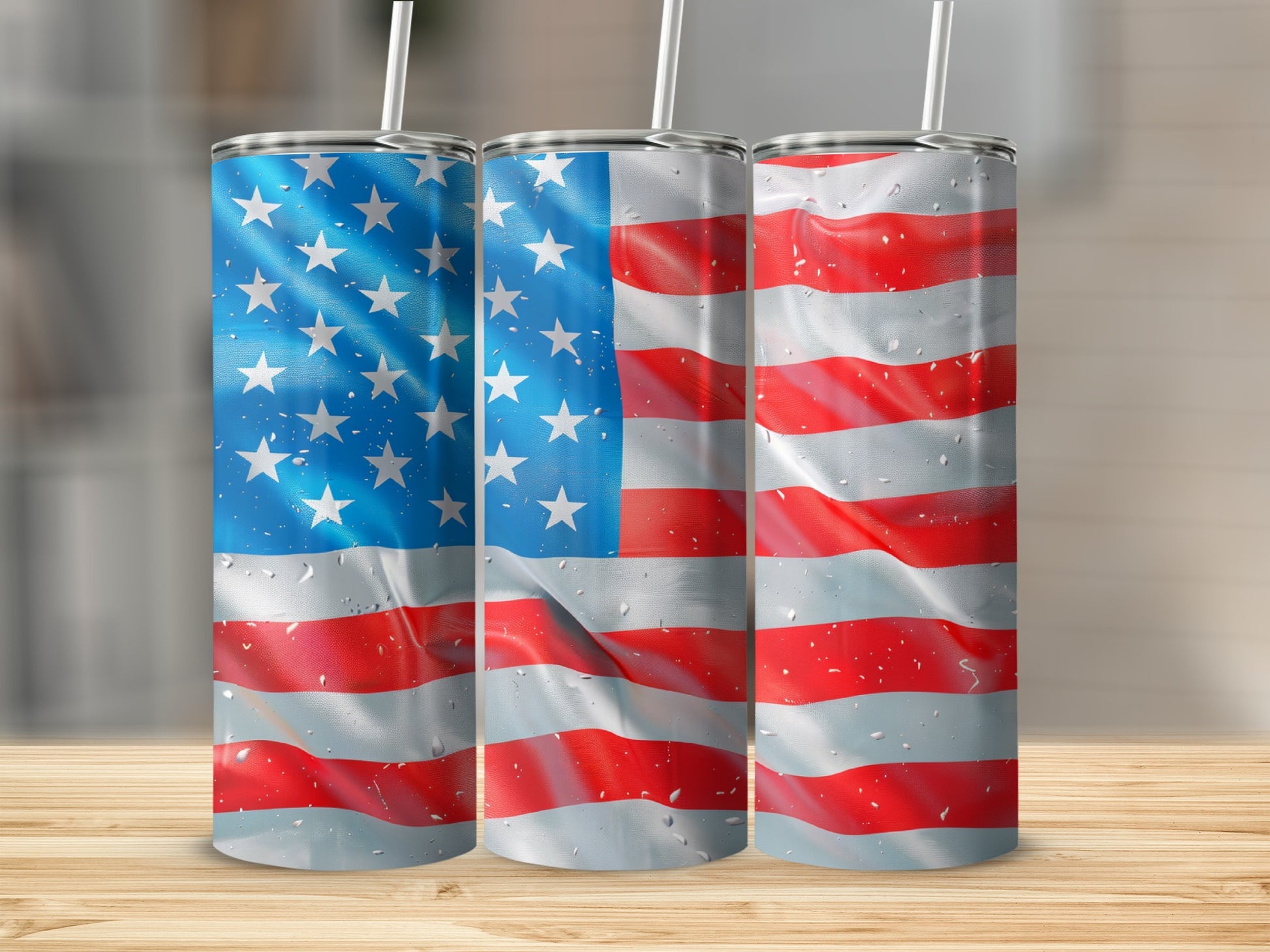 Three tumblers with American flag design on a wooden surface.