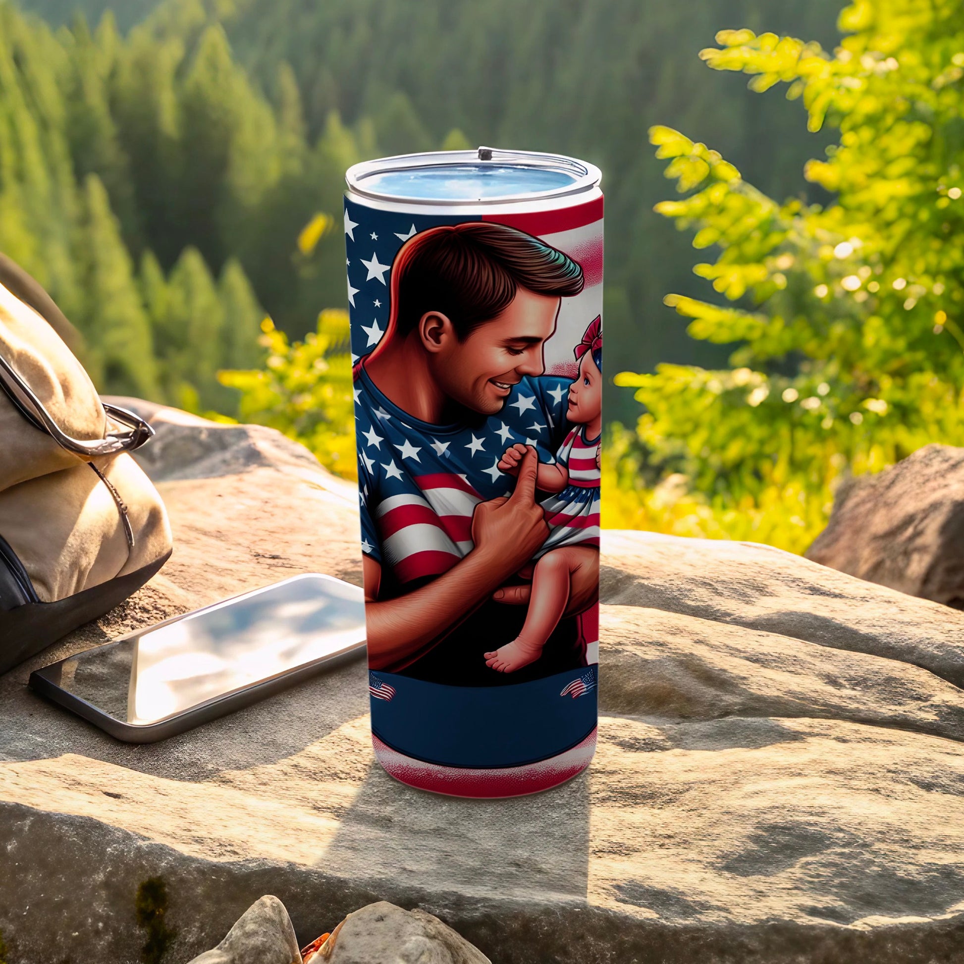 Father in American flag shirt holds baby, outdoors on rocks.