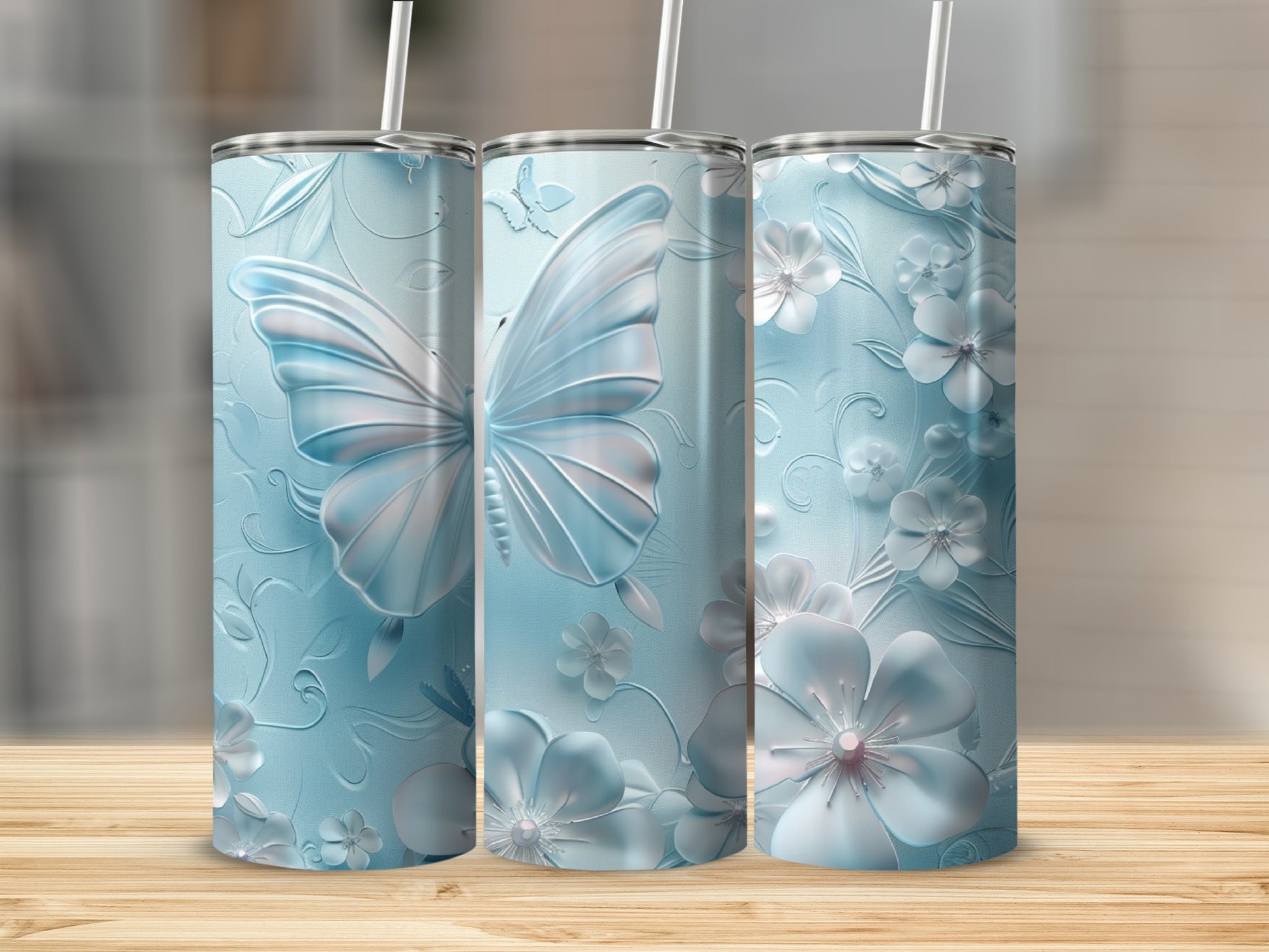 Three light blue tumblers with embossed butterflies and flowers.