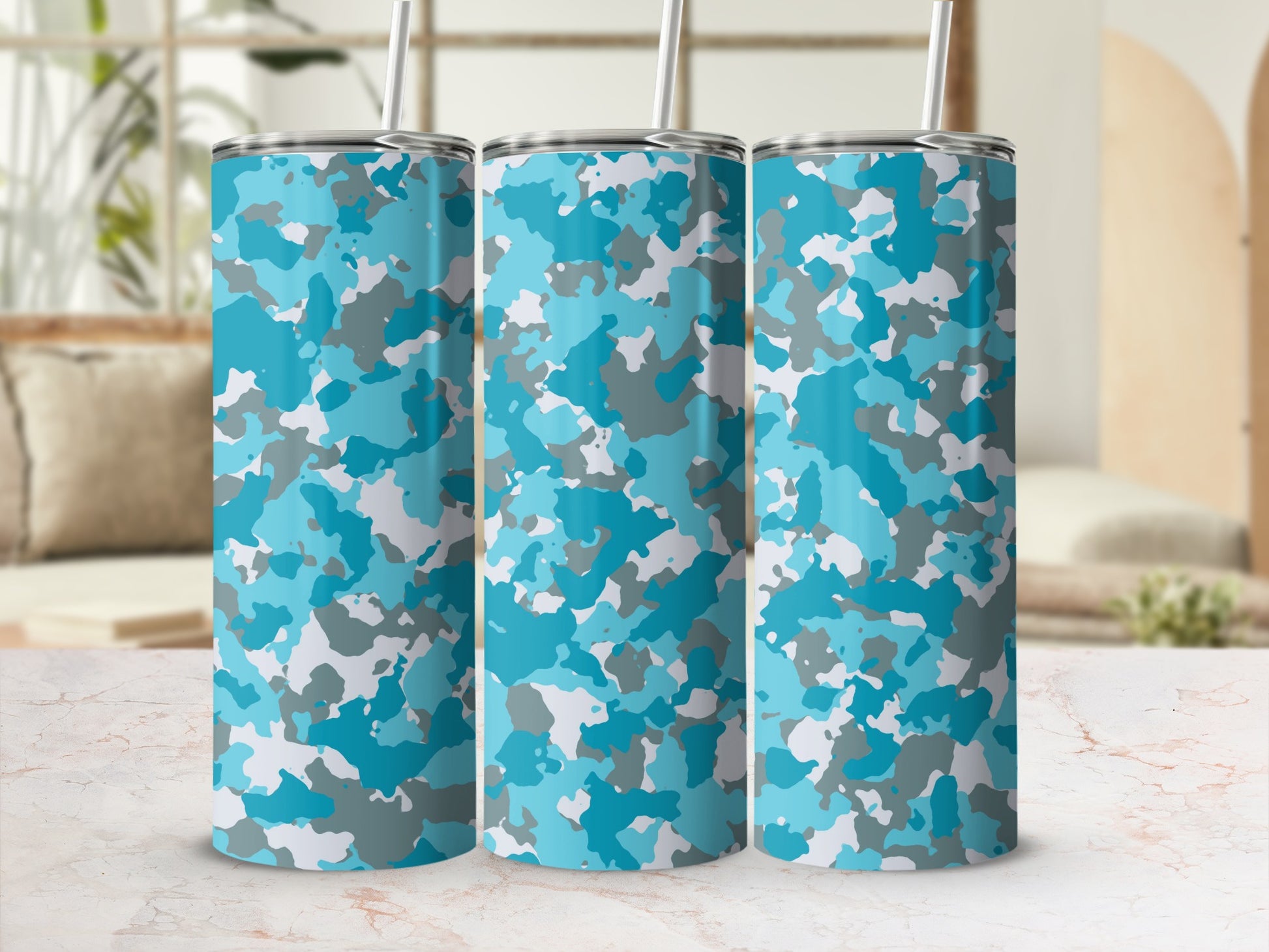 Three tumblers with a blue and gray camouflage pattern and straws.