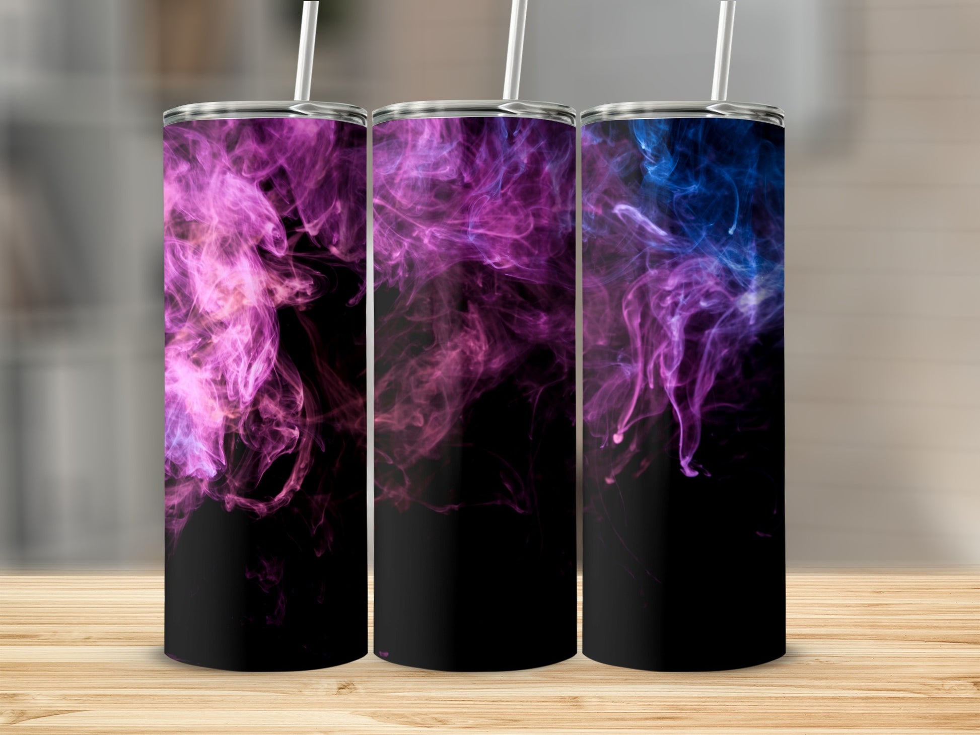 Three tumblers with purple and blue smoke designs on a wooden surface.